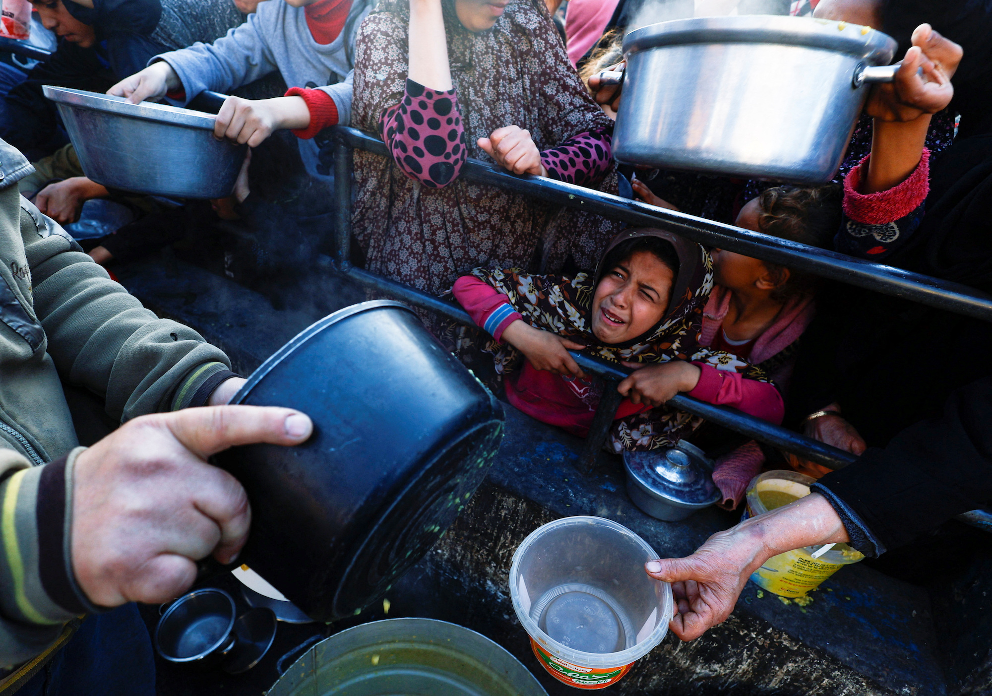 A child reacts as Palestinians wait to receive food��in Rafah, southern Gaza on March 13.