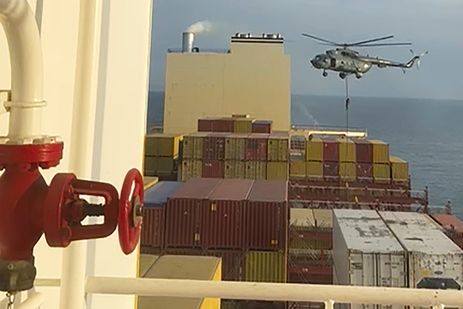 This image made from a video provided to The Associated Press by a Mideast defense official shows a helicopter raid targeting a vessel near the Strait of Hormuz on Saturday, April 13. 