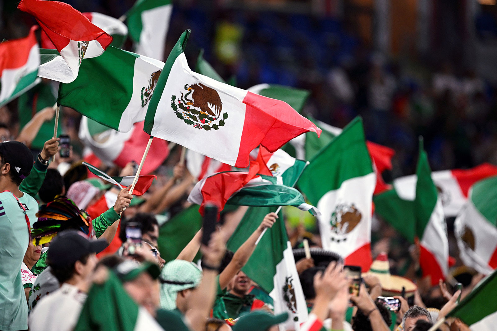 Mexico fans wave country flags ahead of the match between Mexico and Poland on November 22. 