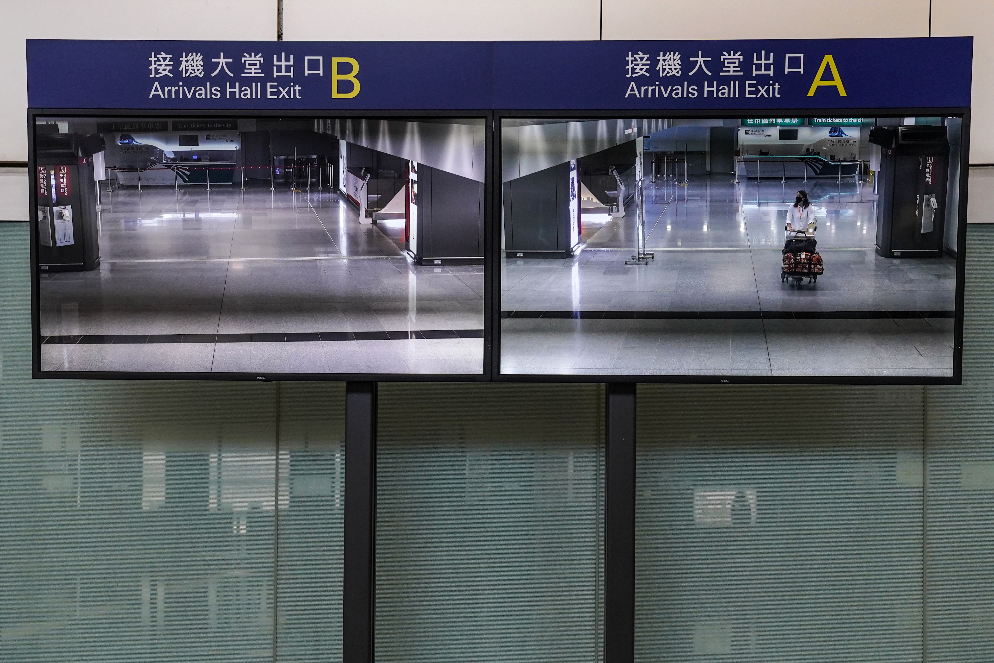 A traveler in the arrivals hall is seen on a screen at Hong Kong International Airport on July 15.