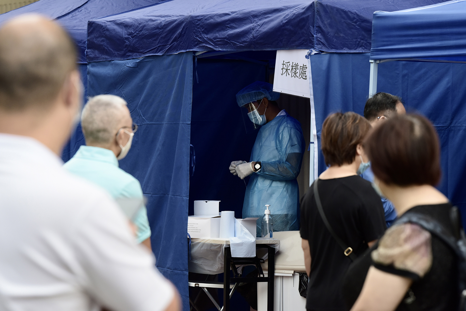 People stand at a Covid-19 testing booth in Hong Kong, on November 9.