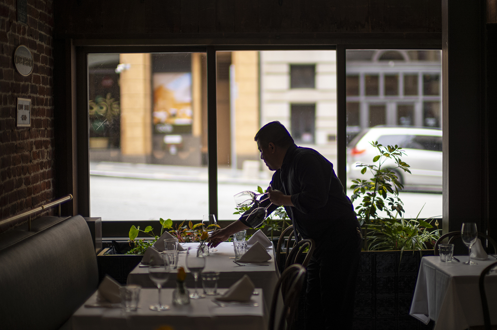 A server sets a table at a restaurant in San Francisco, California, in June.