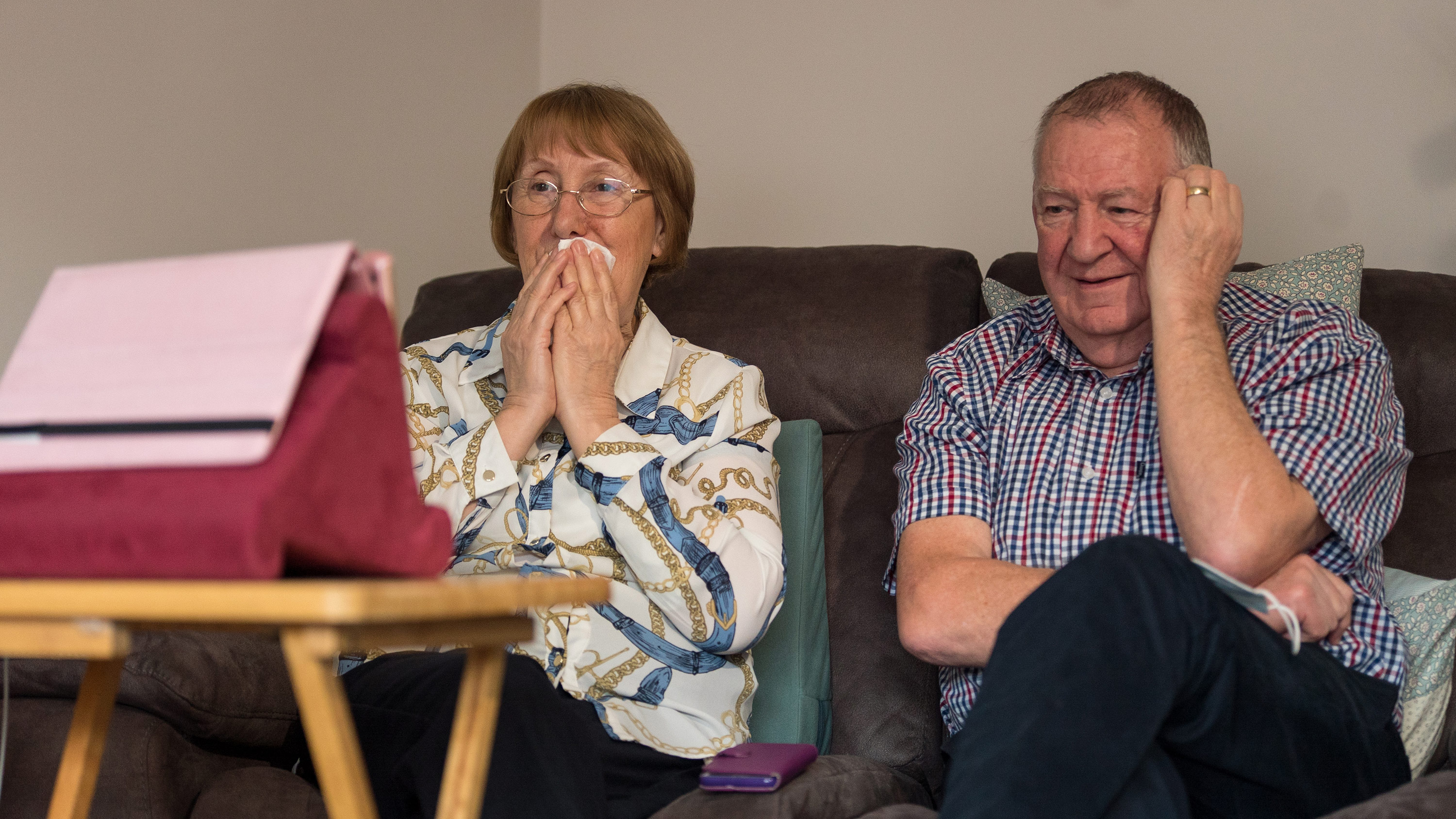 Trish Skinner sits with her husband Peter at home in Northamptonshire as they watch her father's burial service over Zoom.