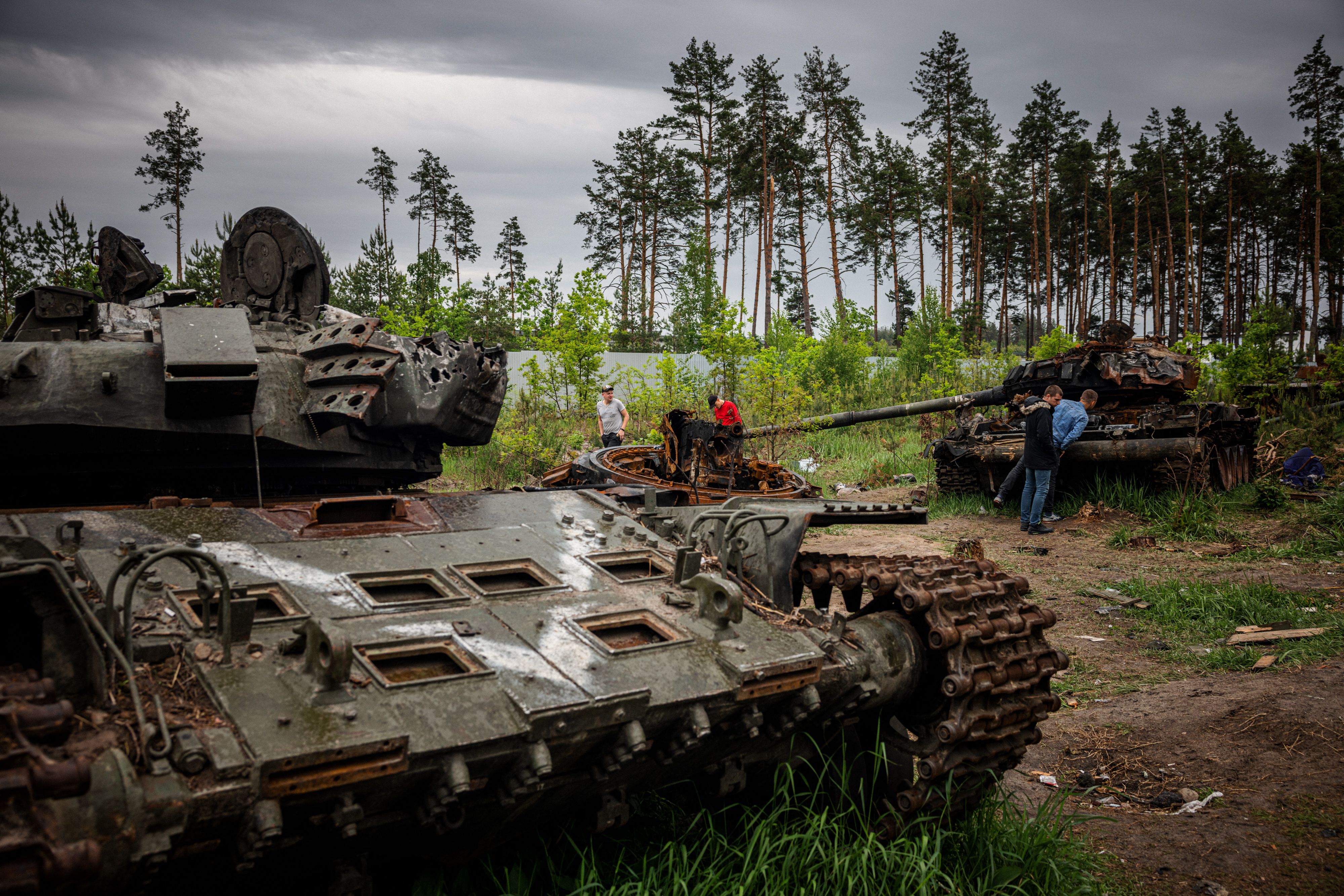 People examine a destroyed Russian tank outside Kyiv, on May 31. 