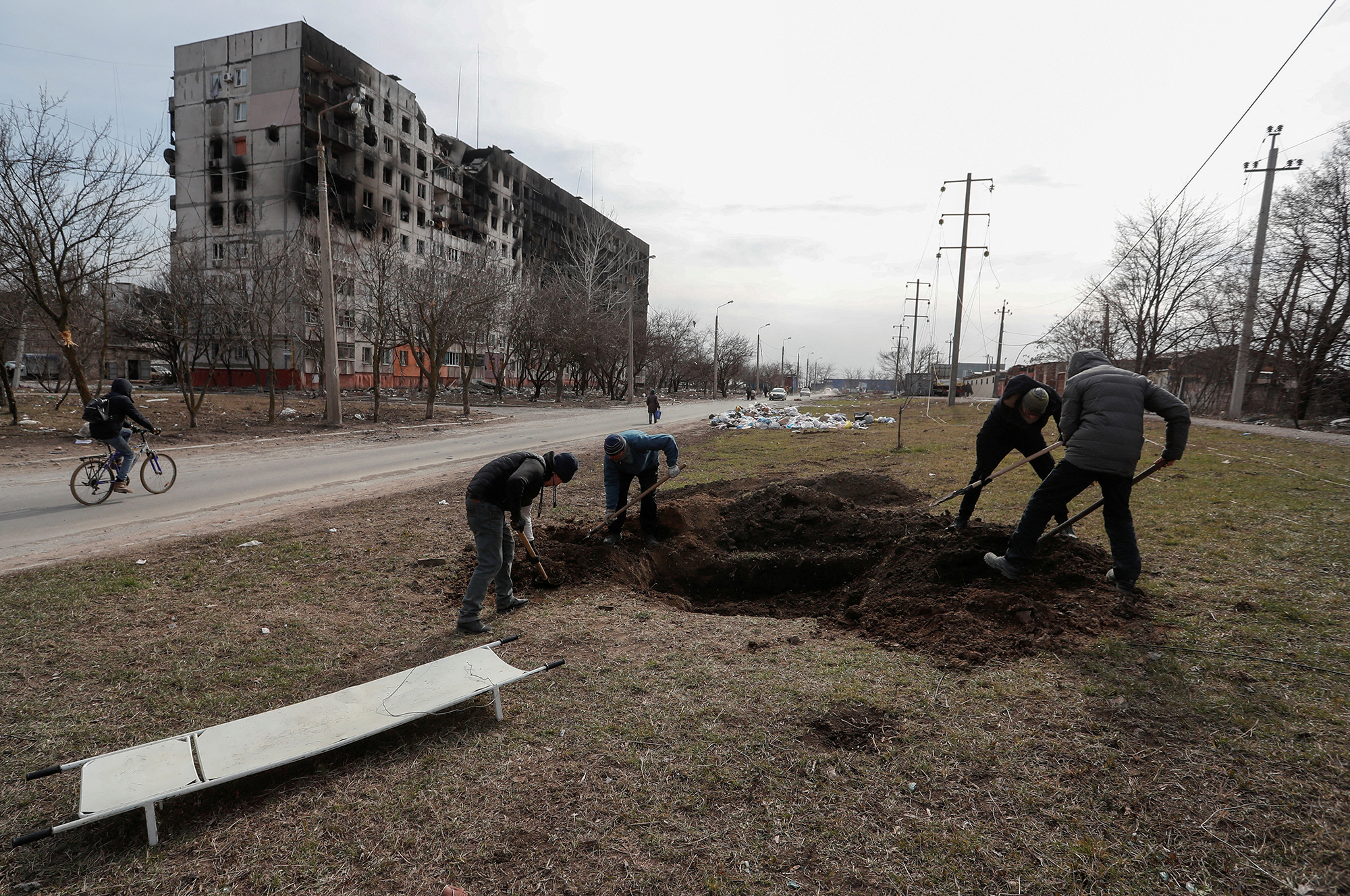People dig a grave in the street in the besieged southern port city of Mariupol, Ukraine, on March 20.