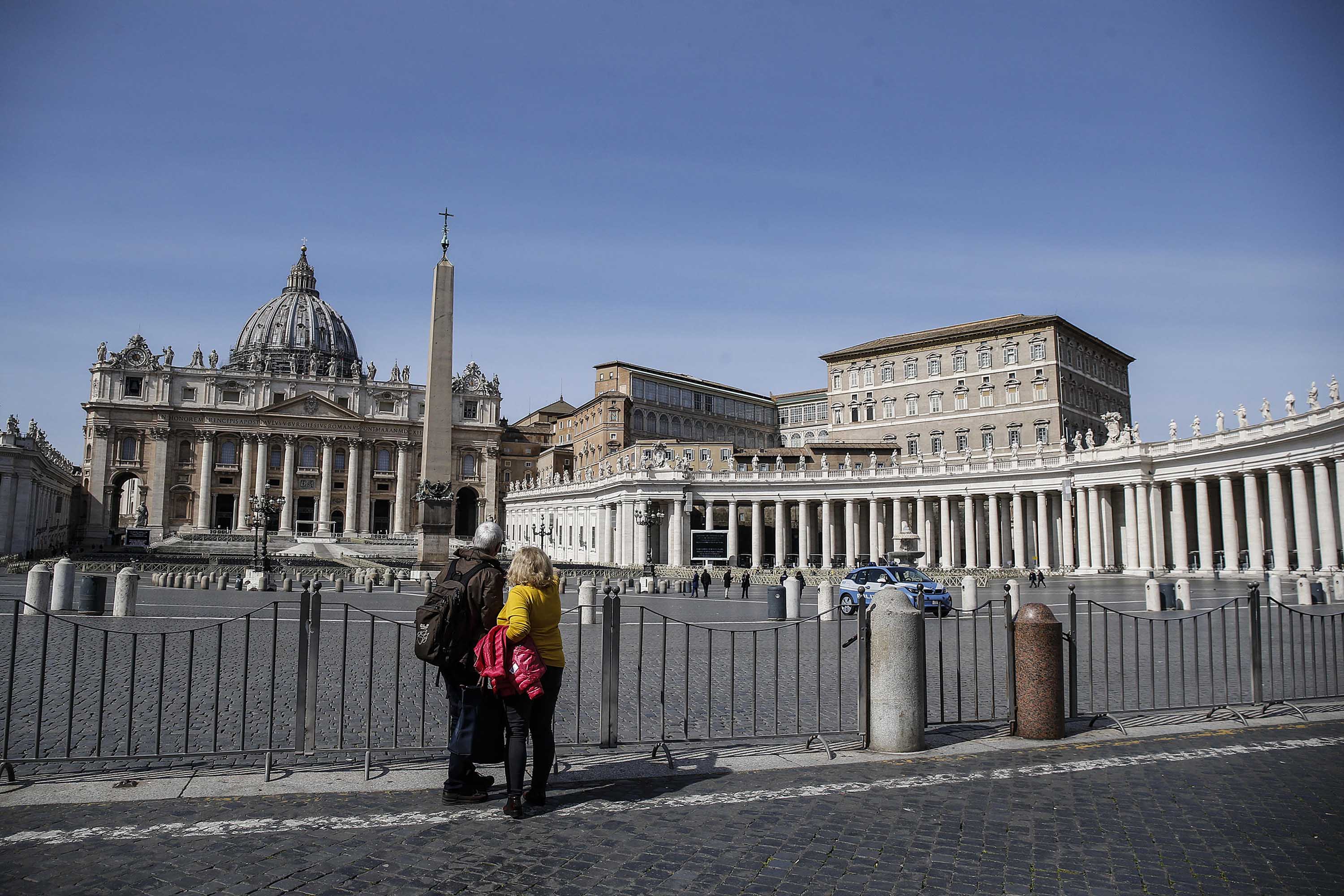 A couple views the closed Saint Peter's Square at the Vatican on Tuesday.