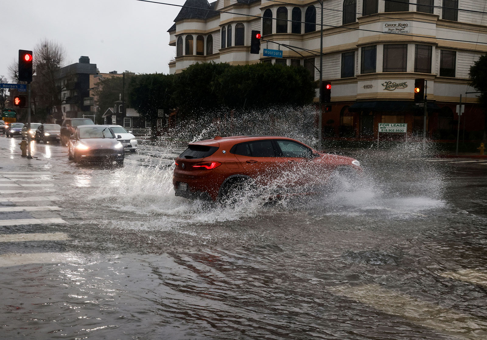 Cars drive on flooded streets in the Studio City area of Los Angeles on Monday.