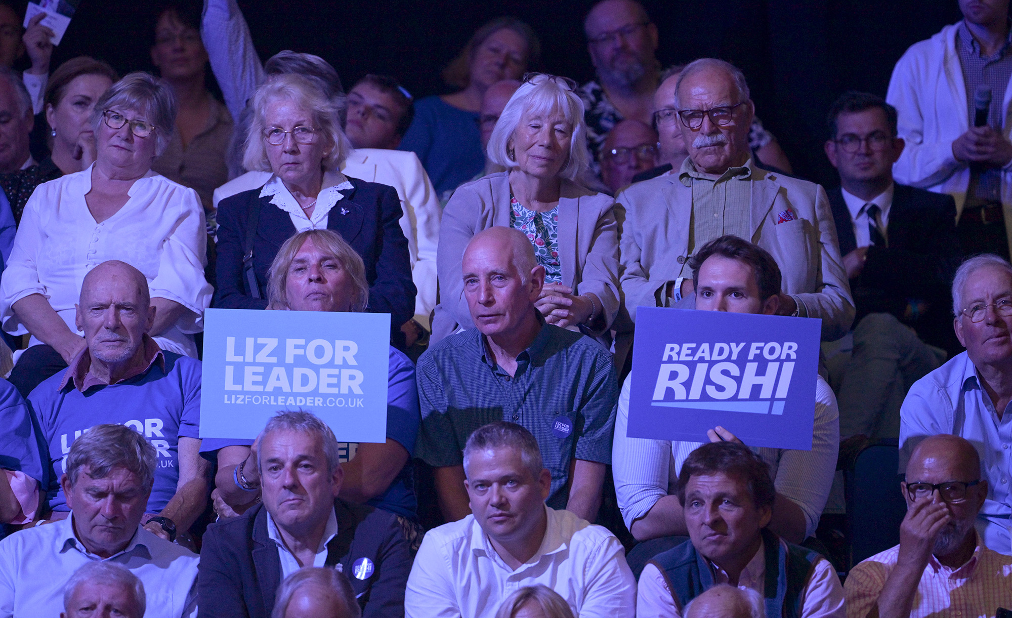 Audience members hold placards showing support for each candidate at a Conservative Party hustings on August 1, in Exeter, England. 