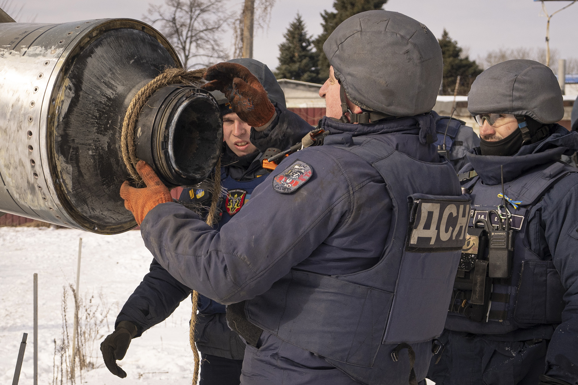 A Ukrainian emergency services employee uses a rope to secure the remains of an S-300 missile fired by Russian forces in Kharkiv, Ukraine, on February 17.