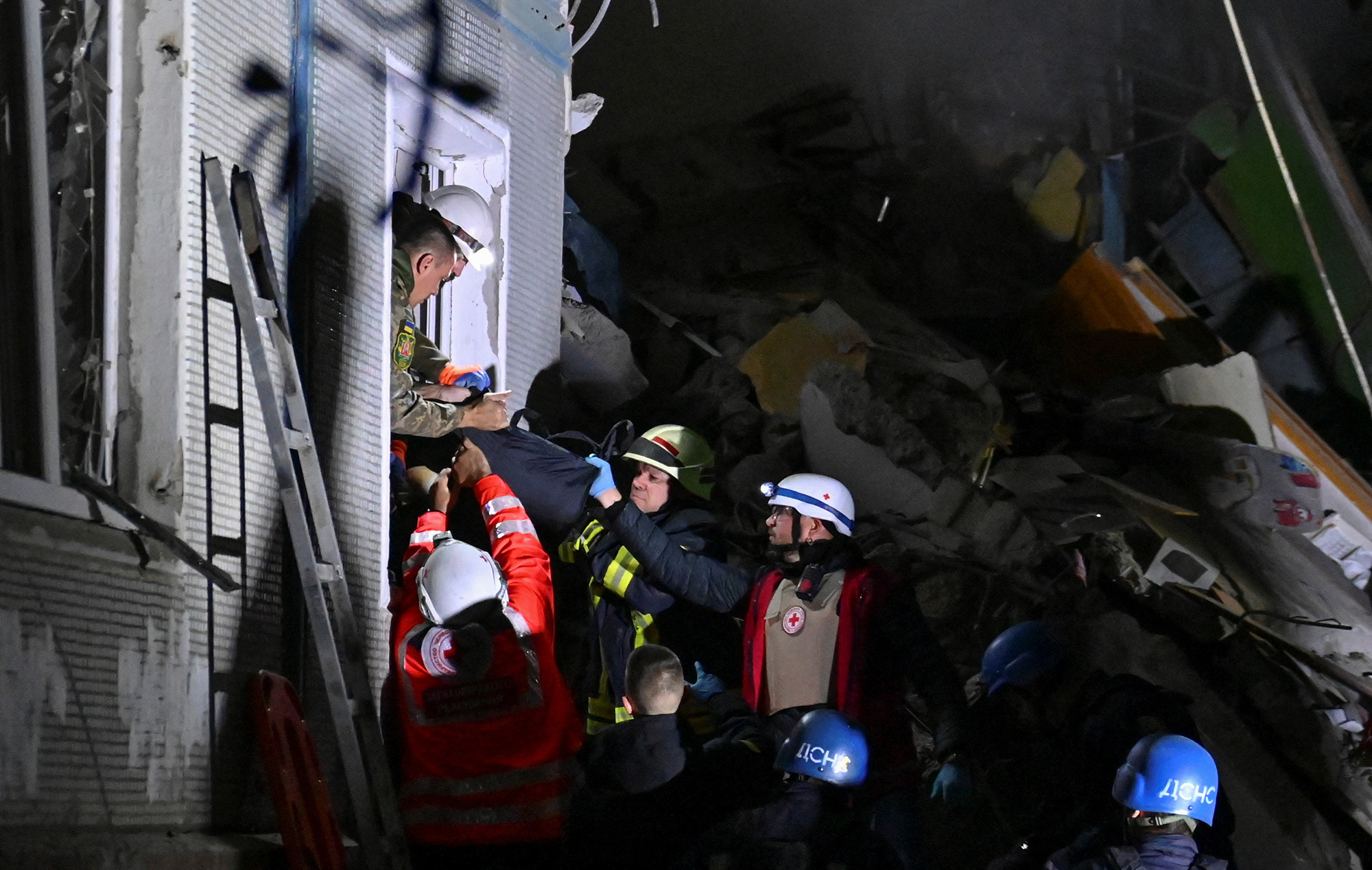 Rescuers carry a person out of a residential building heavily damaged by a Russian missile strike in Zaporizhzhia, Ukraine on October 9.