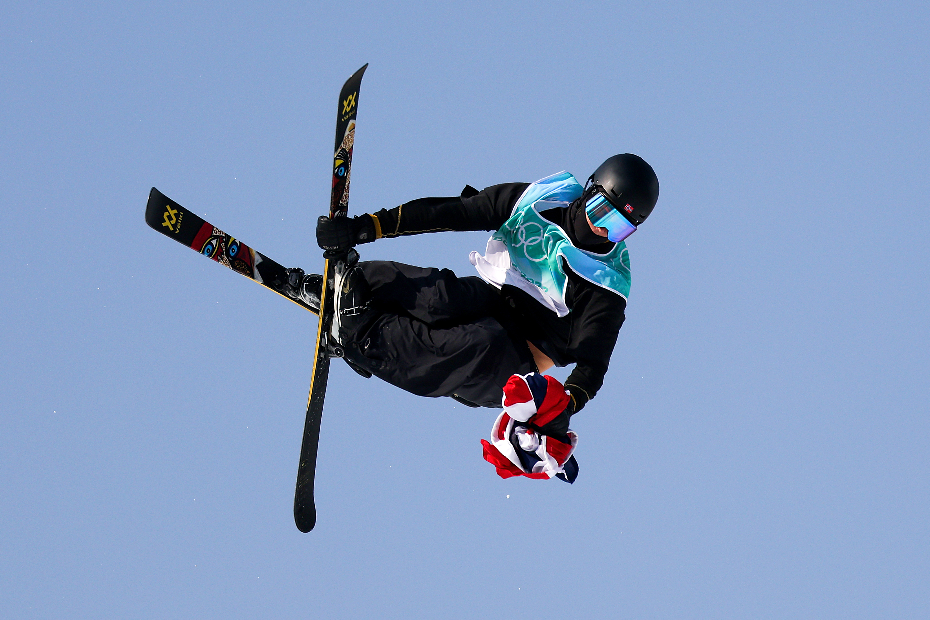 Norway's Birk Ruud performs a trick during the men's freestyle skiing freeski big air final with the Norwegian flag in his hand on Wednesday.