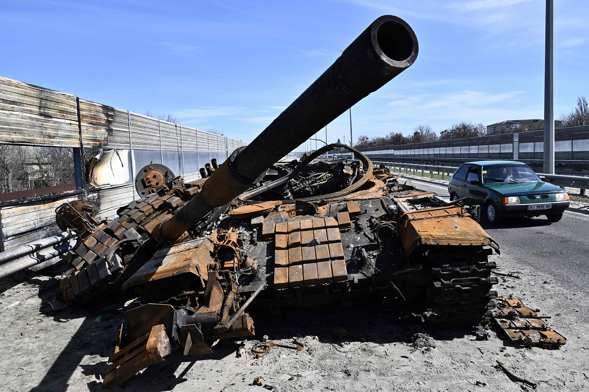 A car drives past a destroyed Russian tank on a road west of Kyiv, Ukraine, on April 7.