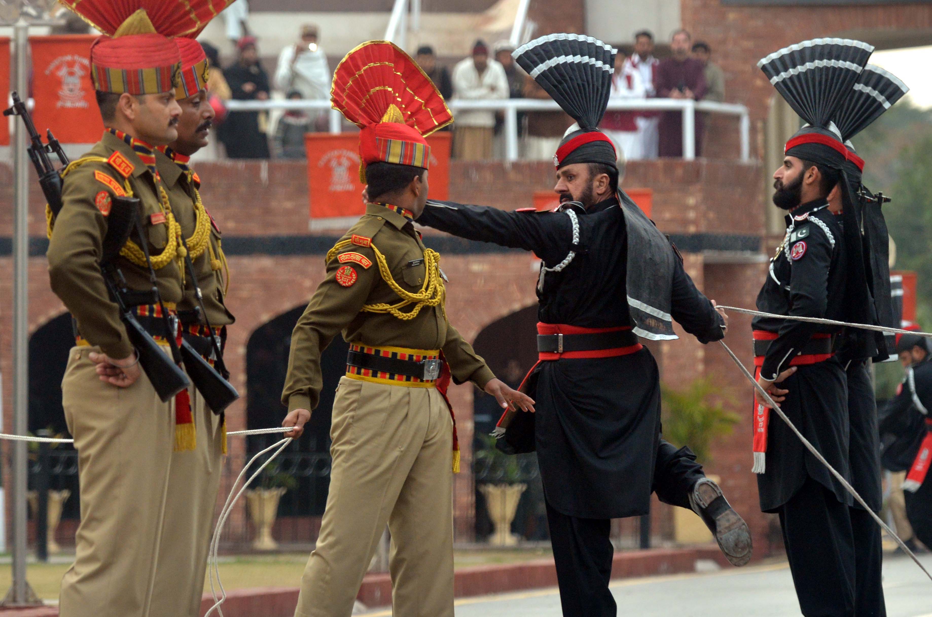 Indian Border Security Force personnel wearing brown uniforms and Pakistani Rangers wearing black uniforms take part in the Beating Retreat ceremony at the India-Pakistan Wagah border post on January 22, 2019.