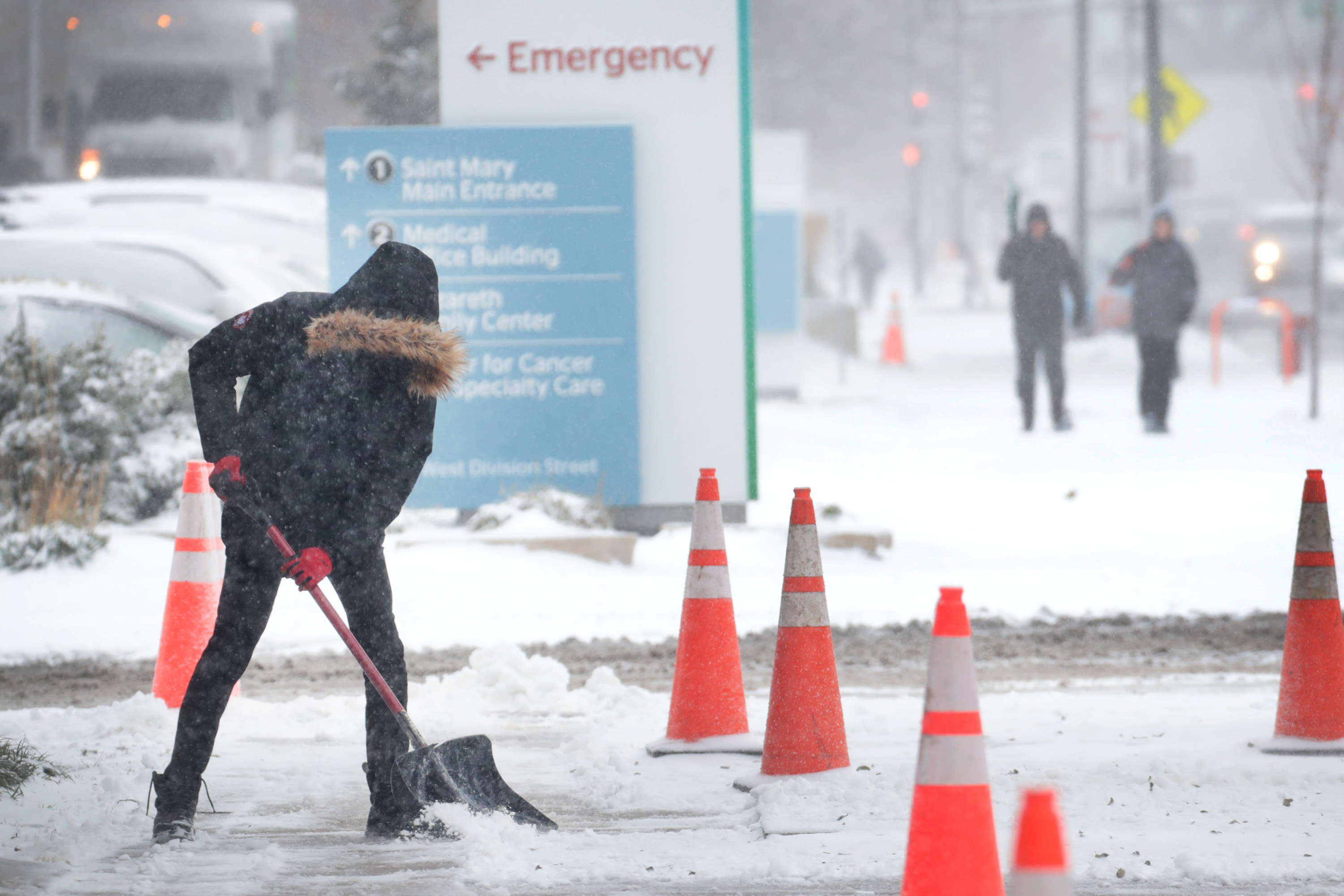 A worker shovels snow from a sidewalk in Chicago on Monday. 