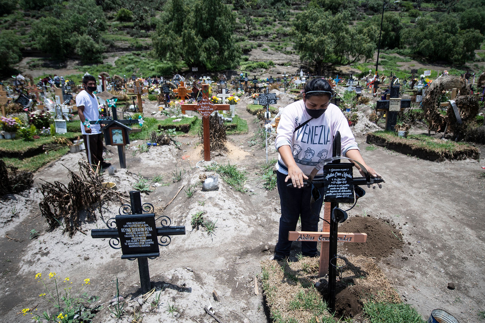 A couple visit the graves of family members who died of Covid-19, at the San Miguel Xico cemetery on August 5, in Mexico. 