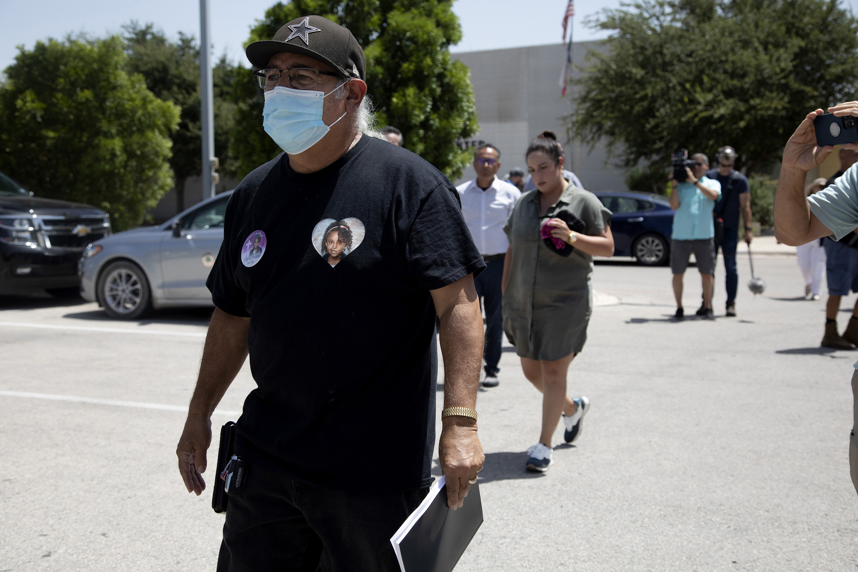 Vincent Salazar, grandfather of Layla Salazar who was killed in the school shooting at Robb Elementary, walks to his vehicle holding his copy of the report.