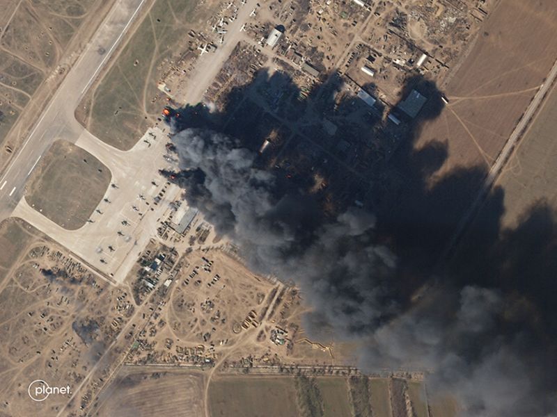 Uma imagem de satélite mostra uma nuvem de fumaça subindo do Aeroporto Internacional de Kherson na terça-feira, 15 de março.  Quando ampliadas, as imagens mostram vários helicópteros em chamas.