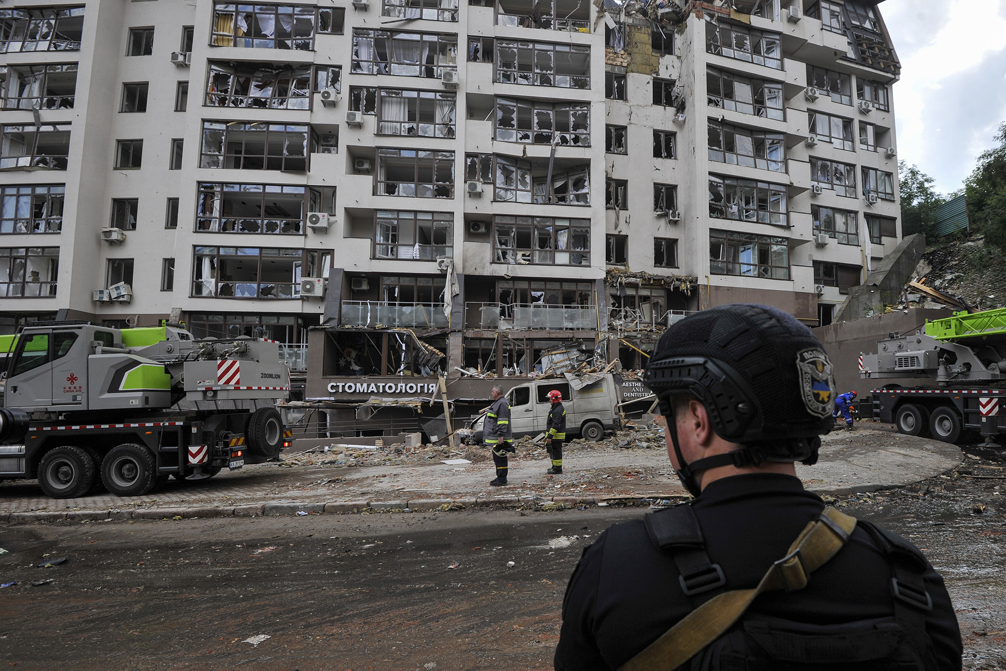 Police stand close to a damaged apartment building following an early morning missile attack in Kyiv, Ukraine, on June 26. 