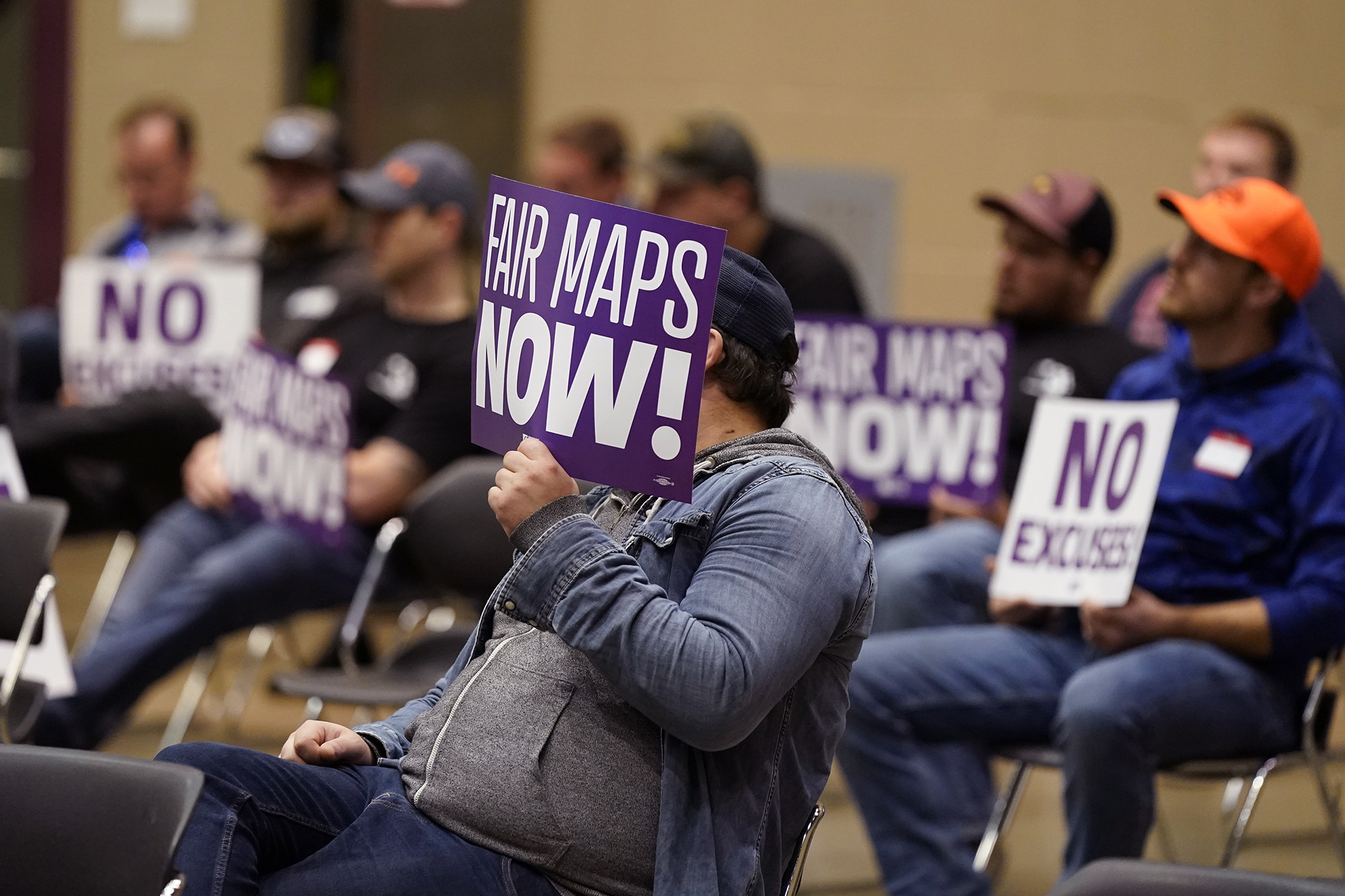 Protesters attend a meeting of Michigan's new Independent Citizens Redistricting Commission in Lansing, Mich., on Oct. 21, 2021.