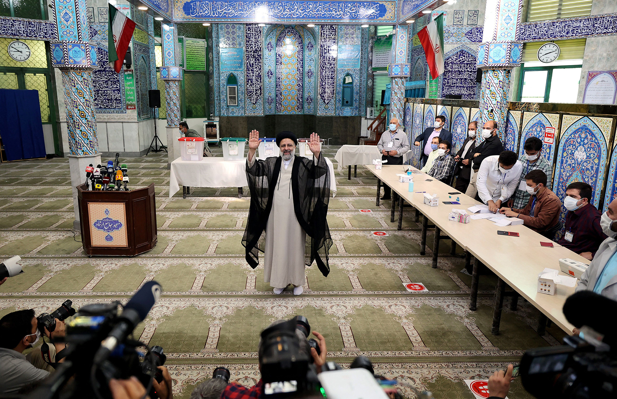 Iranian presidential candidate Ebrahim Raisi waves after casting his ballot for presidential election, in Tehran, Iran, on June 18, 2021.