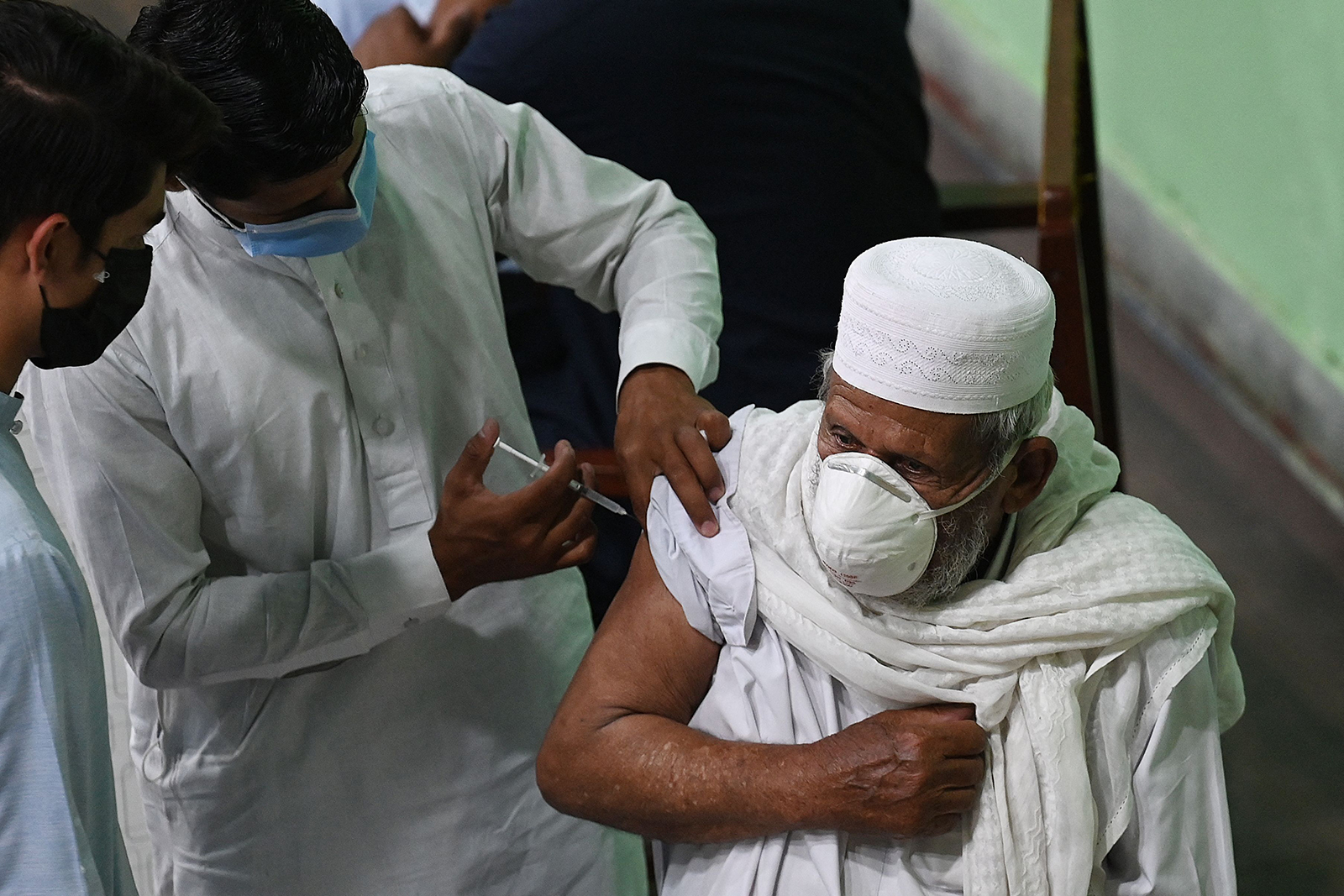 A health worker inoculates a man with a dose of the Sinopharm vaccine at a vaccination center, in Rawalpndi, Pakistan, on May 3.