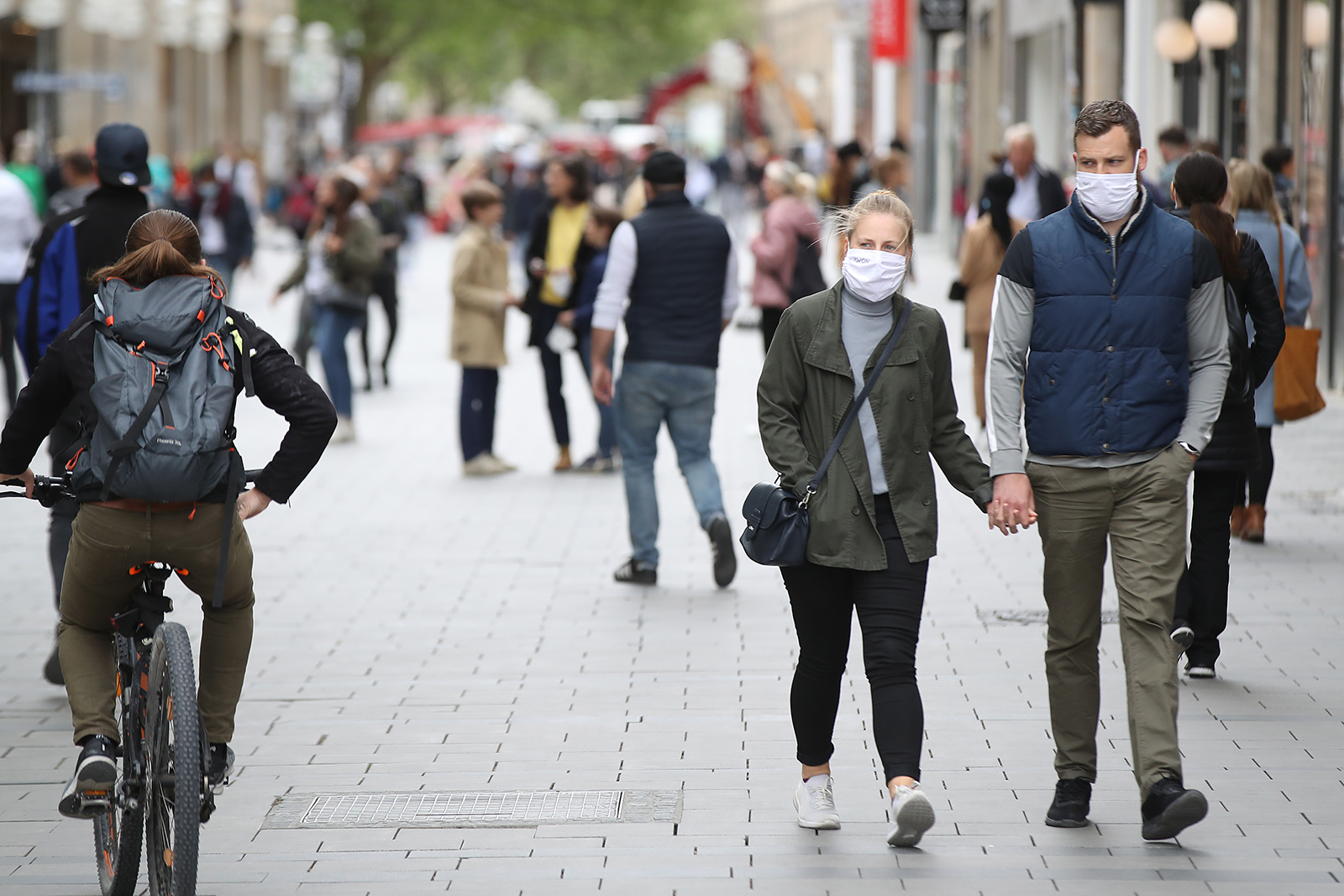 People wearing protective face masks walk on the main shopping street in Munich City during the coronavirus crisis on April 30, in Munich, Germany.