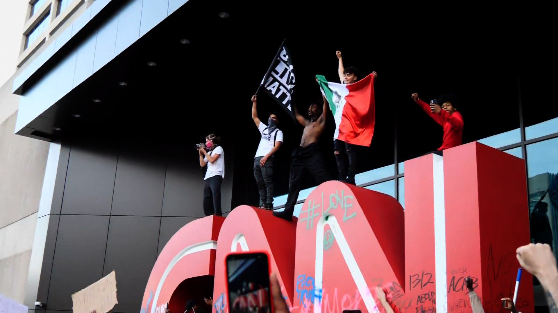 Protesters in Atlanta mount the CNN sign in front of the network headquarters in Atlanta, on Friday, May, 29.  