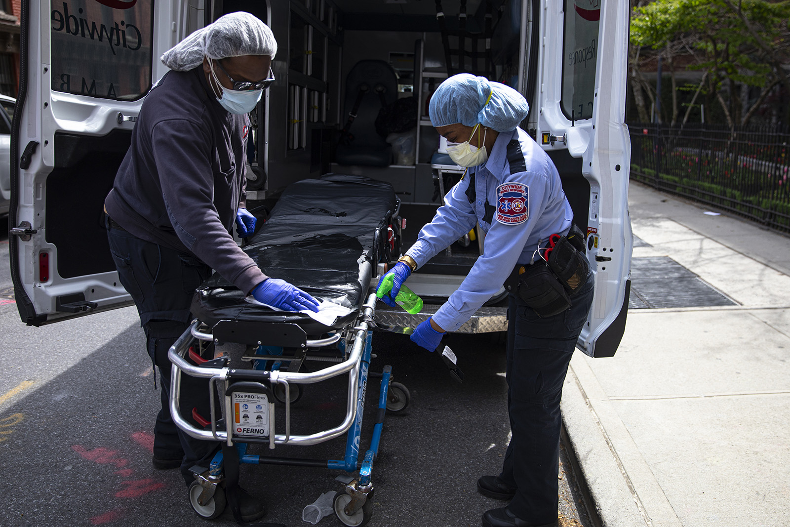 Two emergency medical staff of a private ambulance company sanitize a hospital gurney after they dropped off a patient at the Cobble Hill Health Center April 20, 2020 in the Brooklyn borough of New York City.
