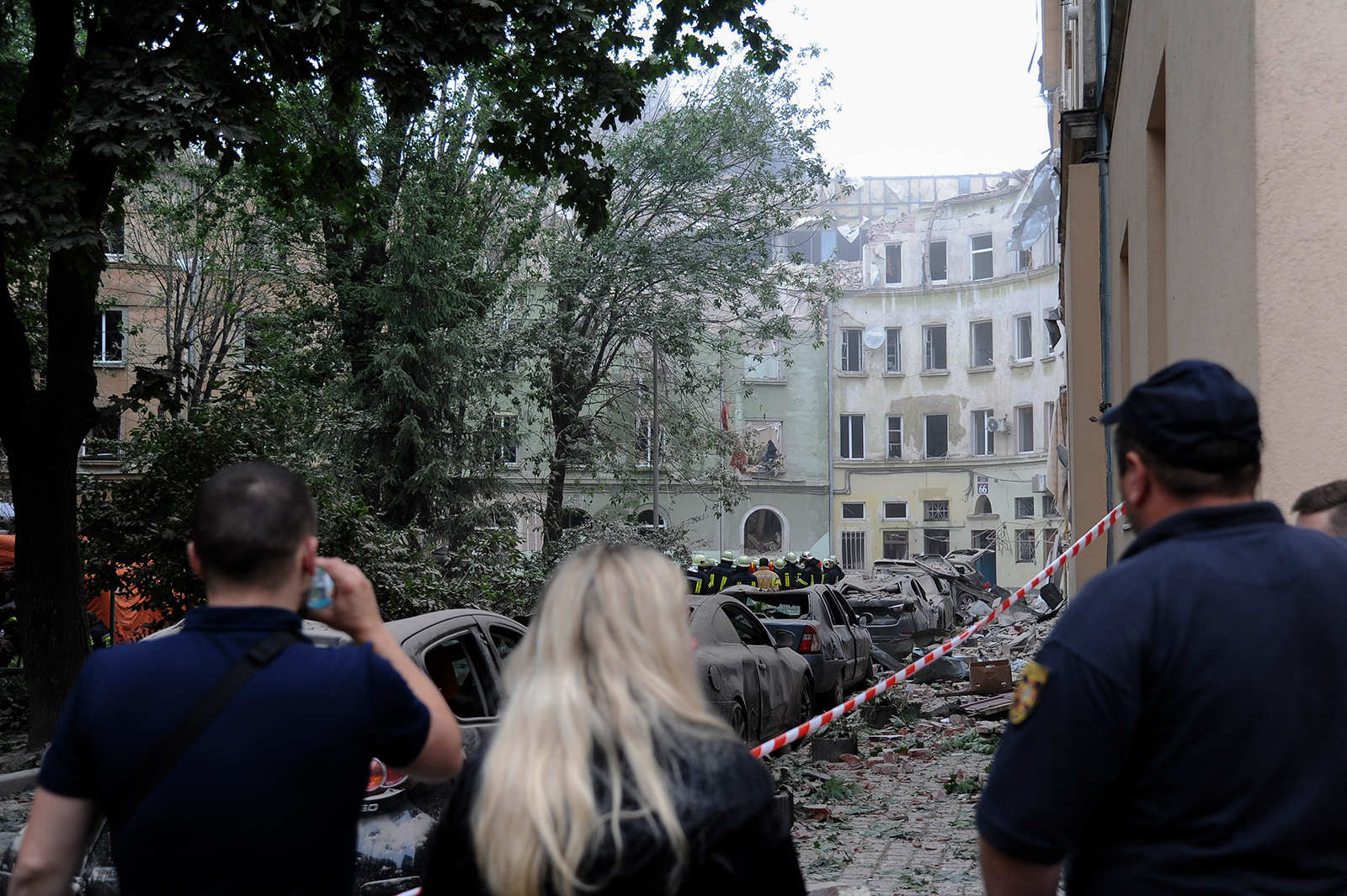 People look at buildings damaged by a Russian missile attack in Lviv, Ukraine, on Thursday, July 6. 