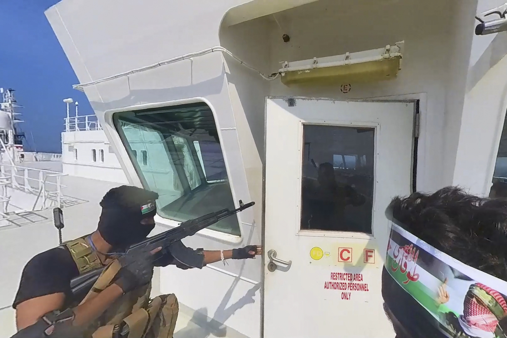 Houthi forces boarding a cargo ship