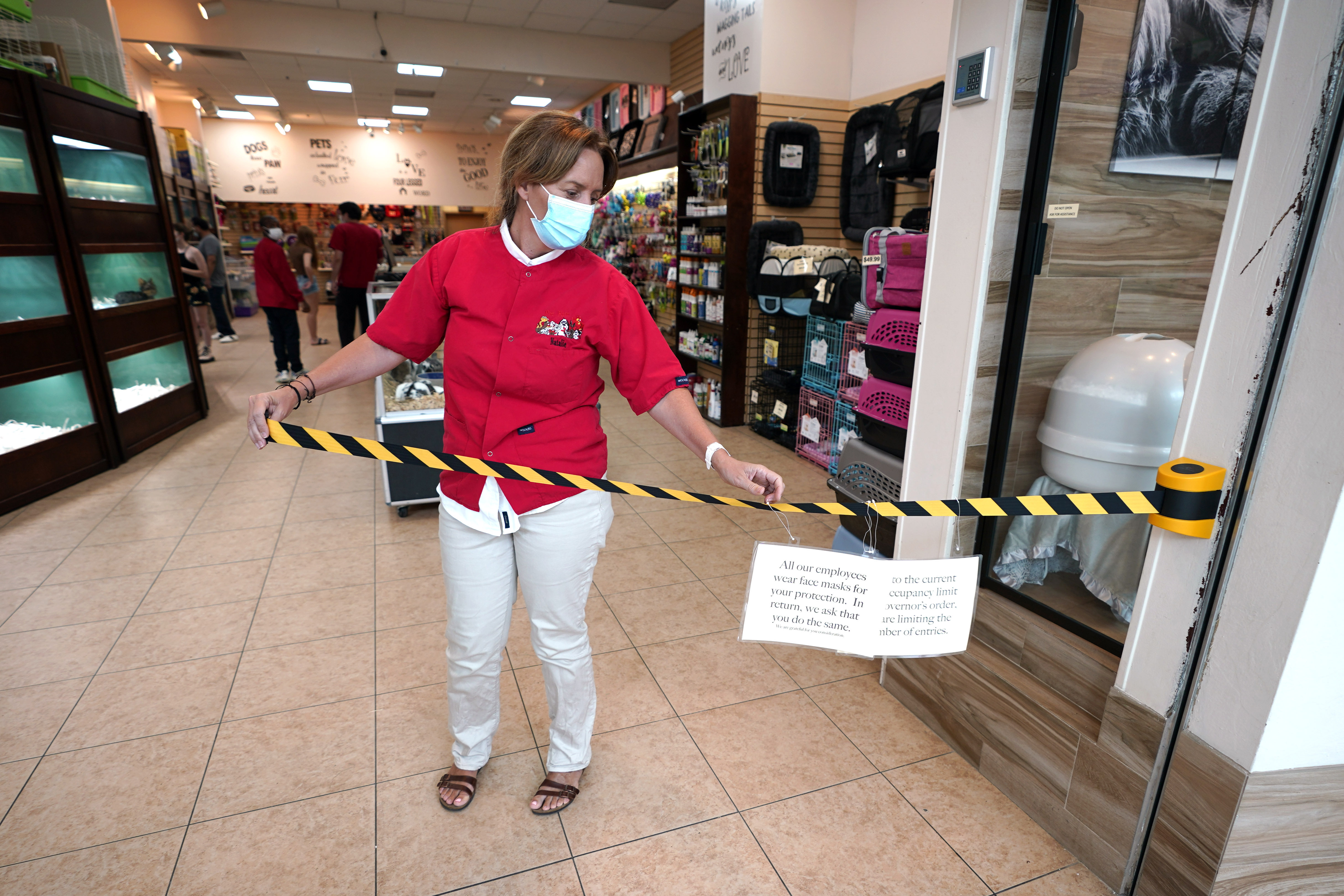 Store manager Natalie Hijazi temporarily closes off the entrance to a Pet Fair store inside The Woodlands Mall on May 5 in The Woodlands, Texas.