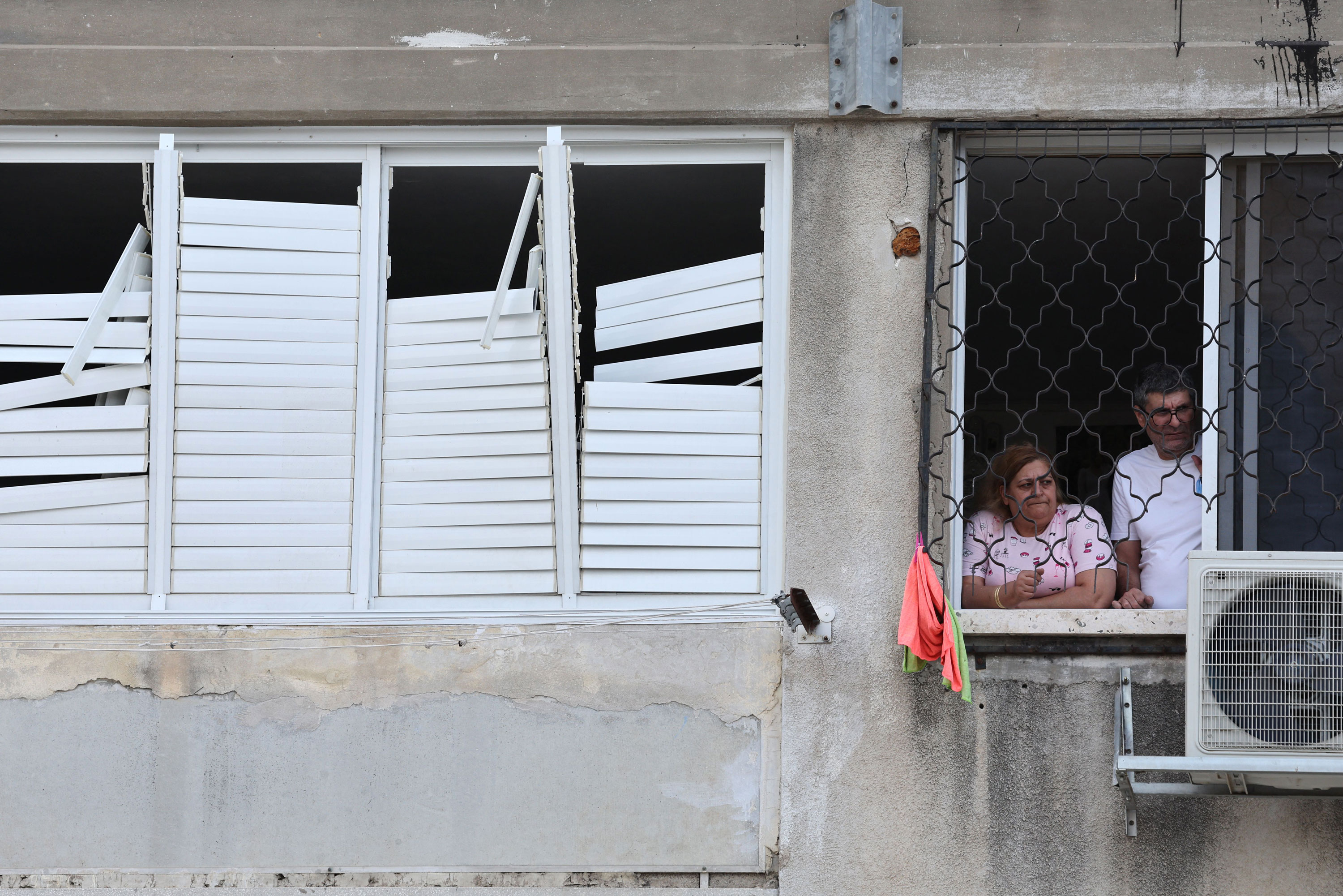 Residents look out from the window of their building in the southern city of Ashkelon, Israel, on October 9, 2023.