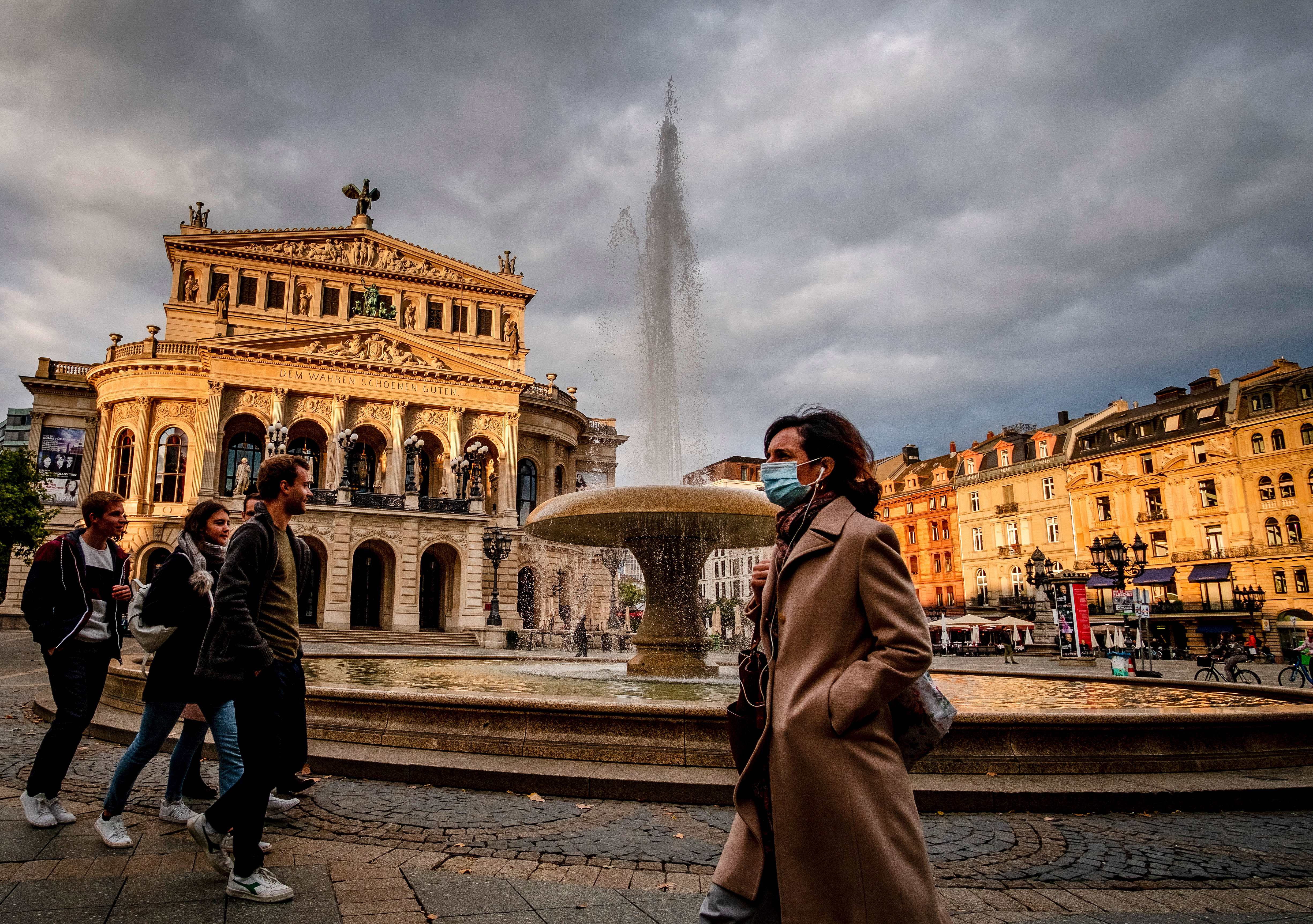 People in Frankfurt, Germany, walk near the Old Opera House on September 28.