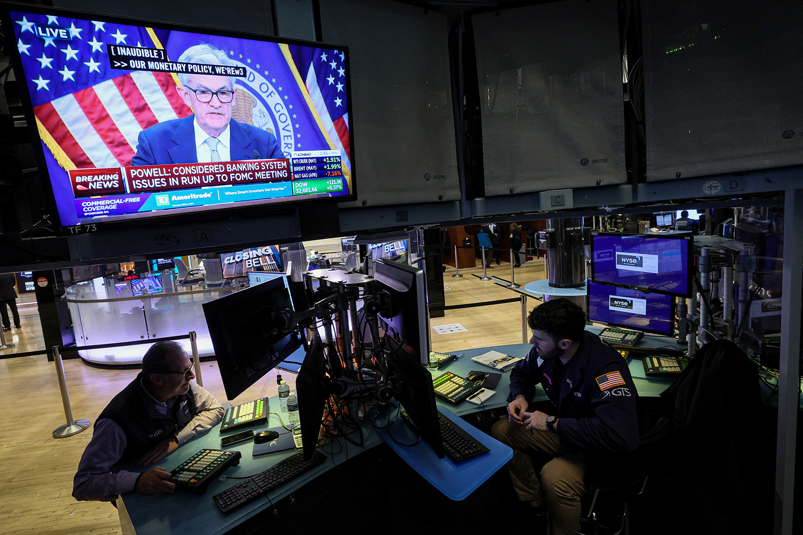 Traders react as Federal Reserve Chair Jerome Powell is seen delivering remarks on a screen, on the floor of the New York Stock Exchange on March 22.
