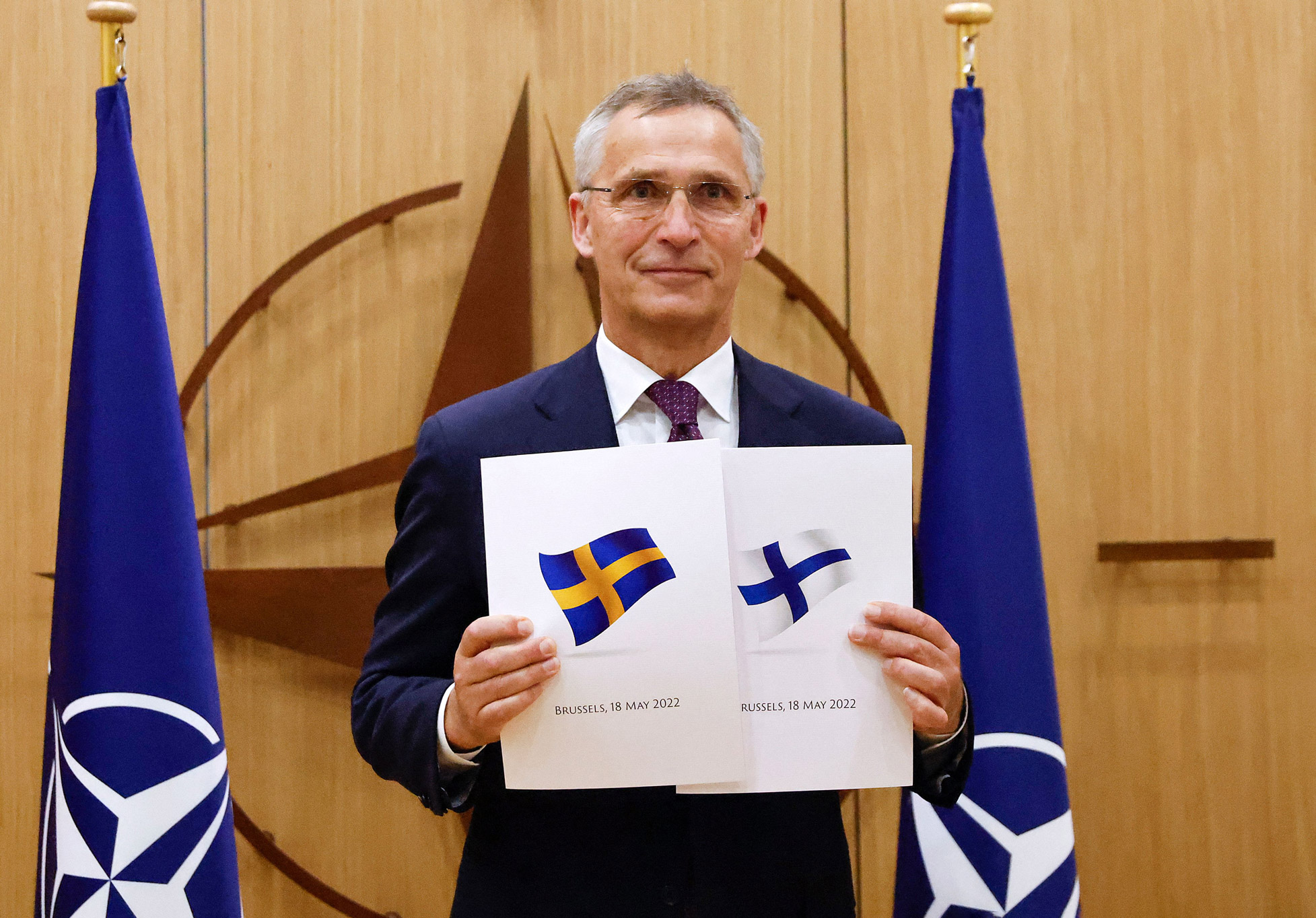 NATO Secretary-General Jens Stoltenberg poses with application documents presented by Finland and Sweden's Ambassadors to NATO during a ceremony in Brussels, on May 18.