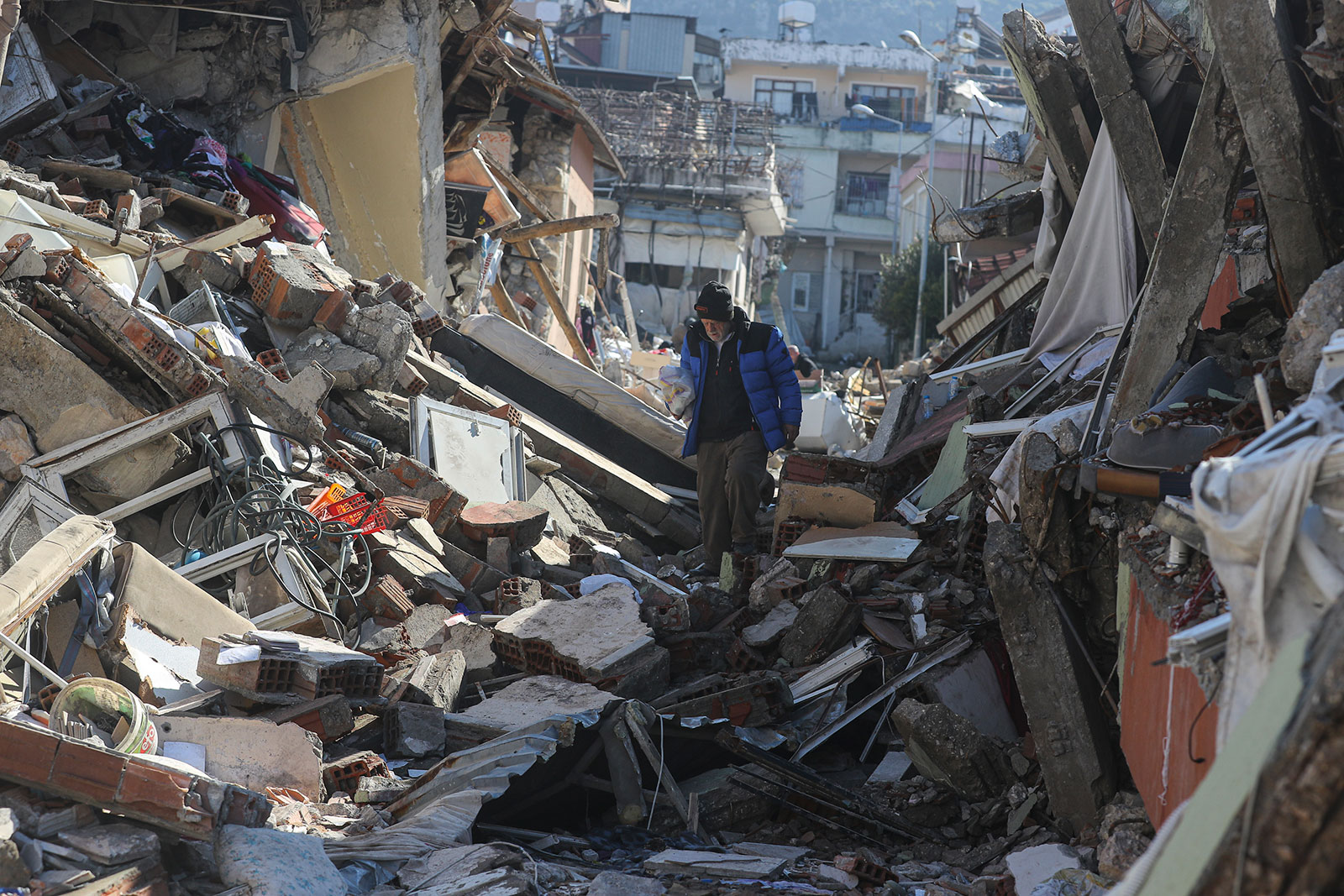 A man walks through the debris of collapsed buildings in Hatay, Turkey, on Thursday. 
