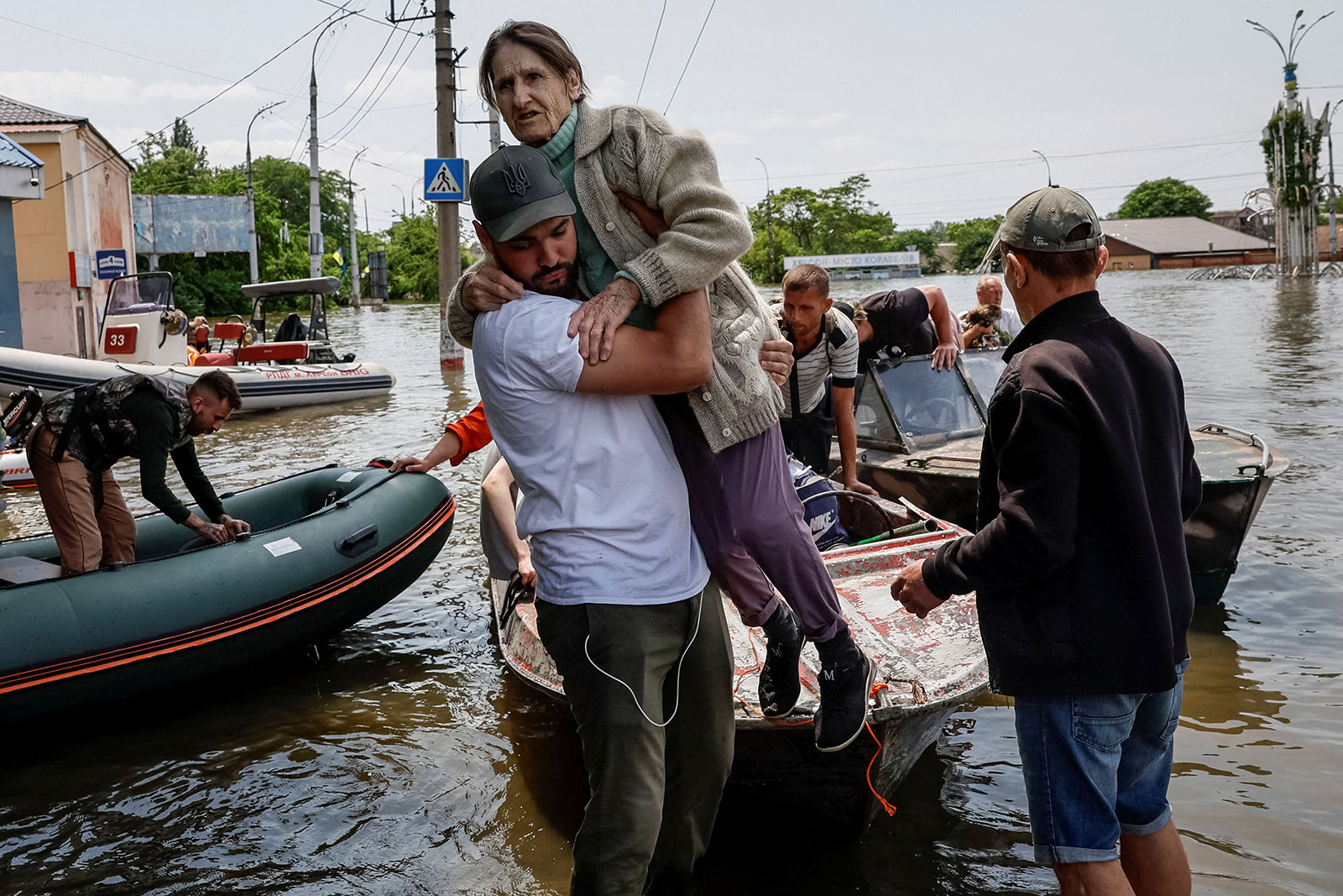 Volunteers evacuate local residents from a flooded area in Kherson, Ukraine on Thursday, June 8.