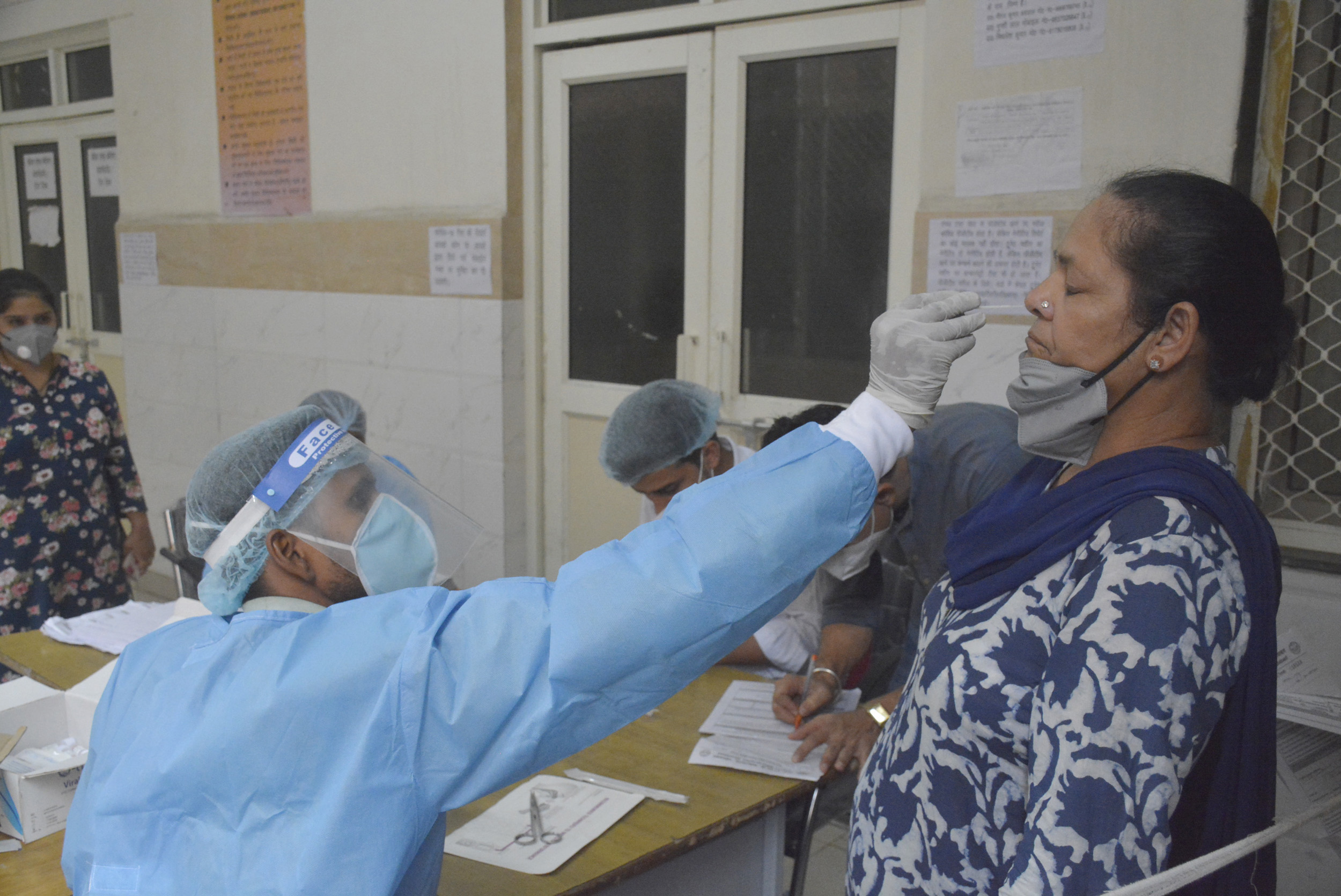 A medical professional collects swab sample to test for Covid-19 infection, at MMG hospital, on July 11, in Ghaziabad, India.