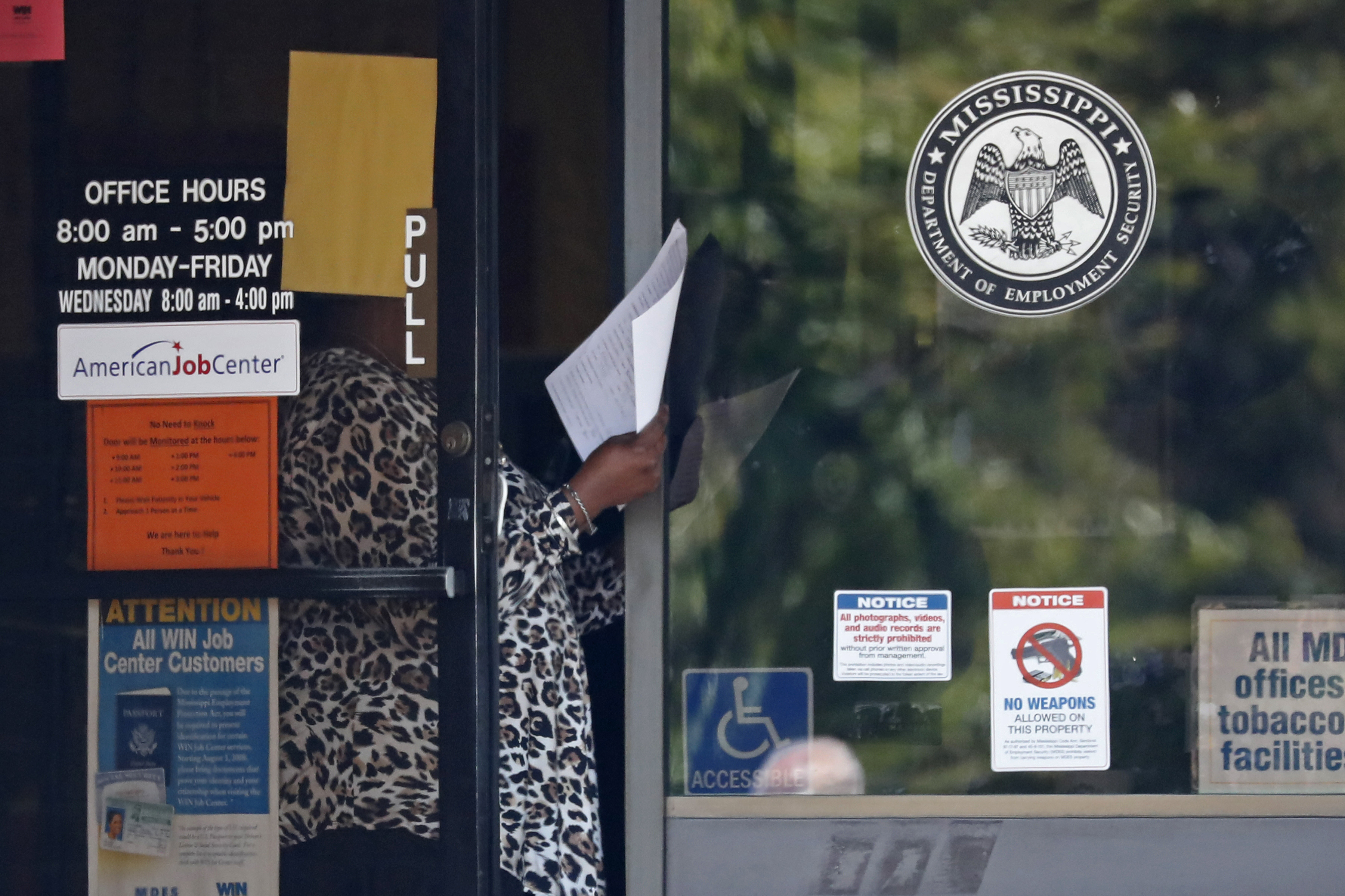 A worker at a WIN job center in Pearl, Mississippi, holds an unemployment benefits application form as she waits for a client on April 21.