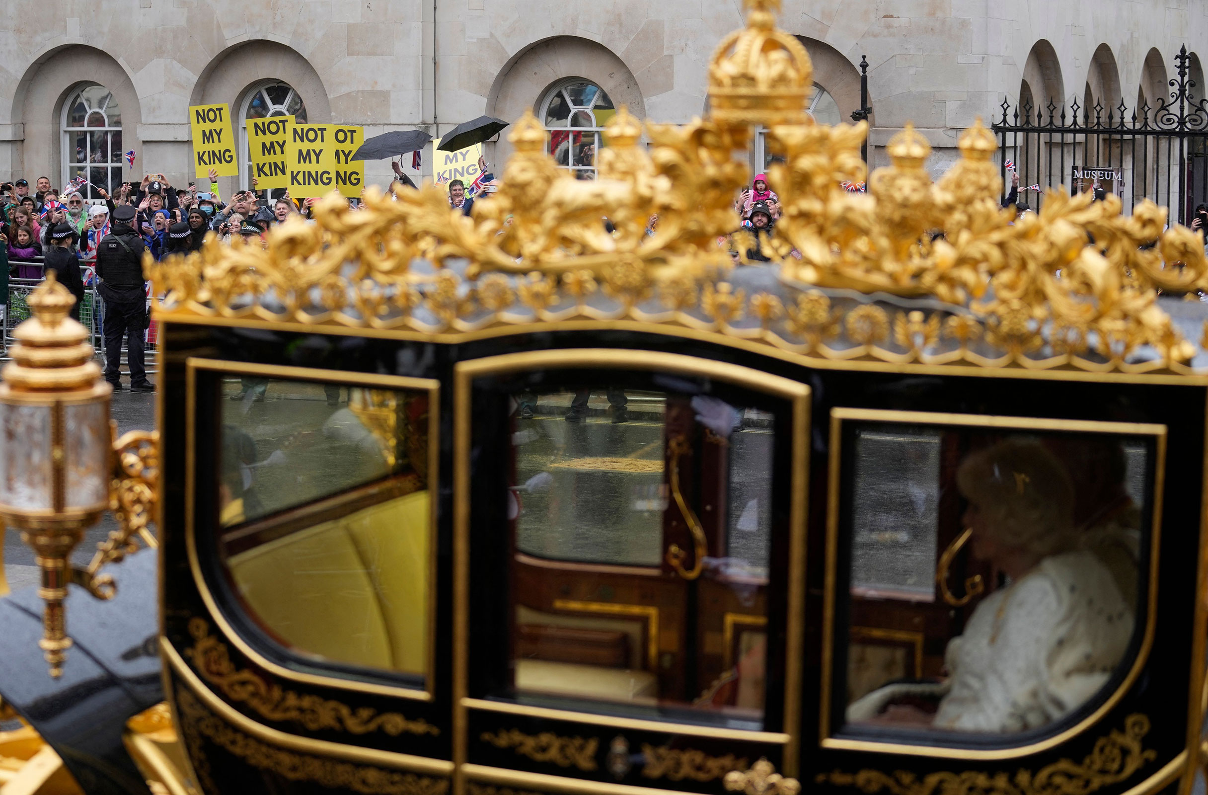 People protest as Britain's King Charles III and Britain's Camilla, Queen Consort travel in the Diamond State Coach, in the 'King's Procession', a journey of two kilometres from Buckingham Palace to Westminster Abbey in central London on May 6, ahead of their coronations. 