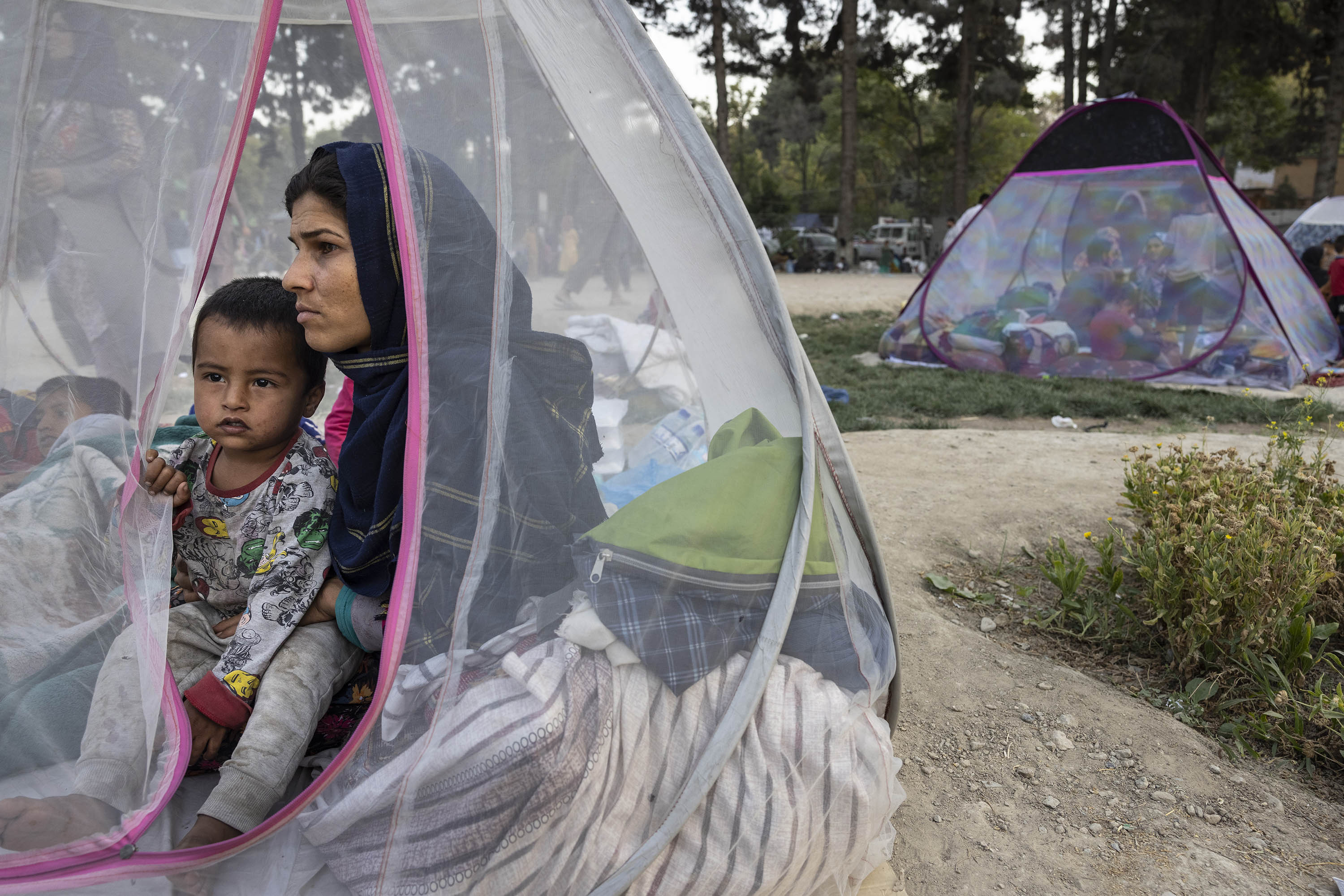 Displaced Afghans sit in a tent at a makeshift IDP camp at a park Kabul, Afghanistan, on August 12.