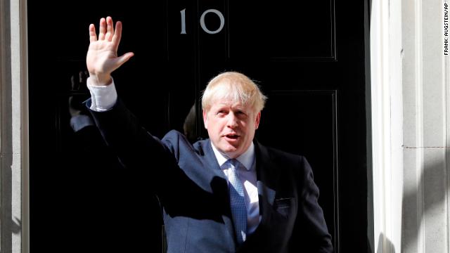 Boris Johnson waves on the doorstep of 10 Downing Street after taking office on Wednesday.