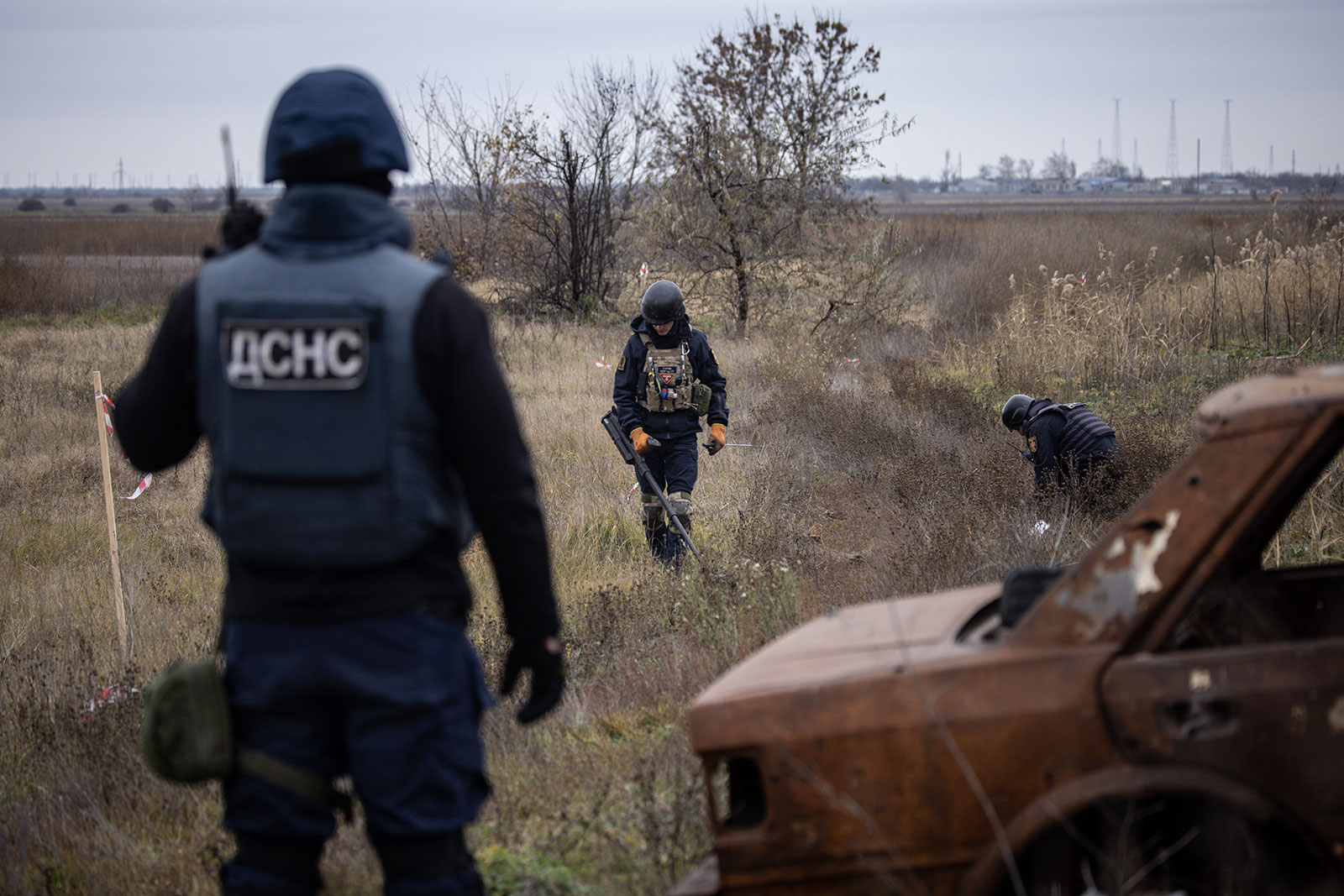 Members of a demining team work to clear mines and unexploded ordinance from the side of the main road leading to Kherson city on November 16 in Kherson, Ukraine. 