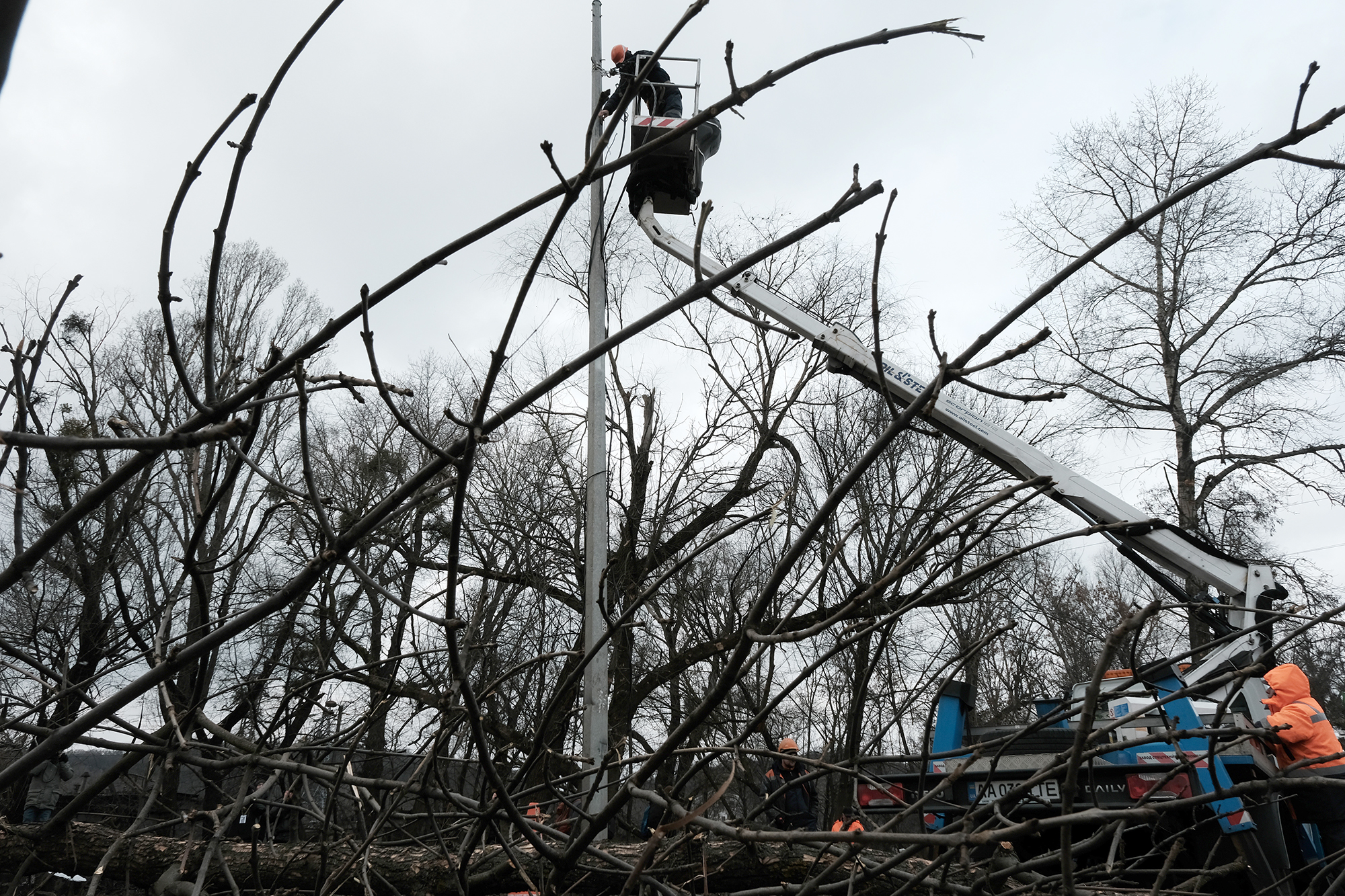 Employees with an electric company work in an industrial area in Kyiv to restore electricity following a morning missile strike in Kyiv, Ukraine, on January 26.