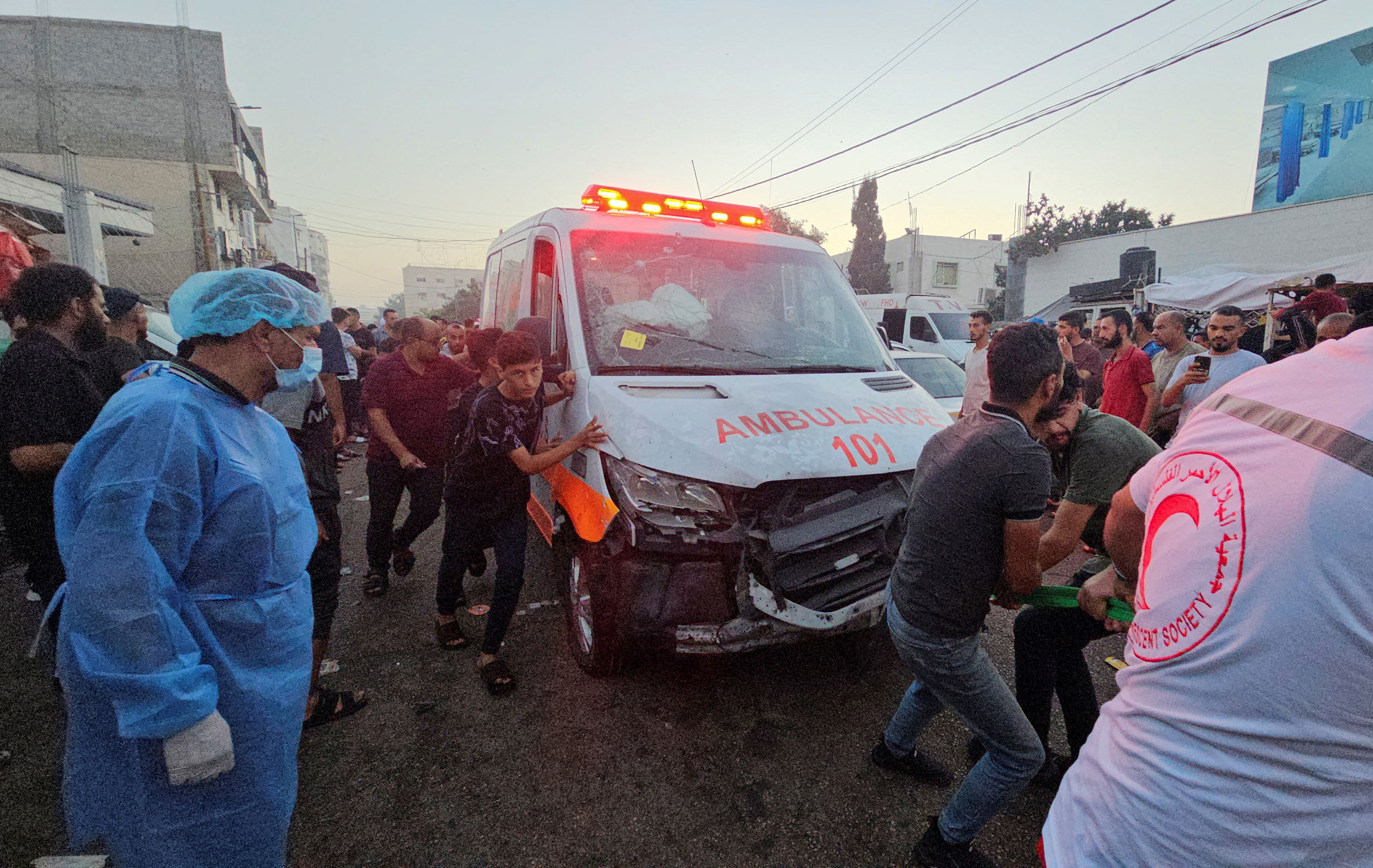 Palestinians pull an ambulance after a convoy of ambulances was hit near the entrance of Al-Shifa hospital in Gaza City.