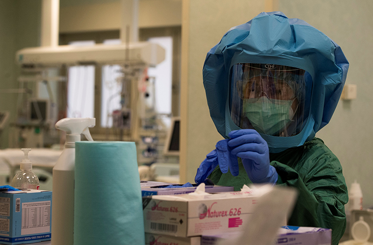 A health worker puts on her personal protective equipment (PPE) before starting to work at the intensive care unit, treating COVID-19 patients, of the Tor vergata hospital in Rome, on Tuesday May 12.