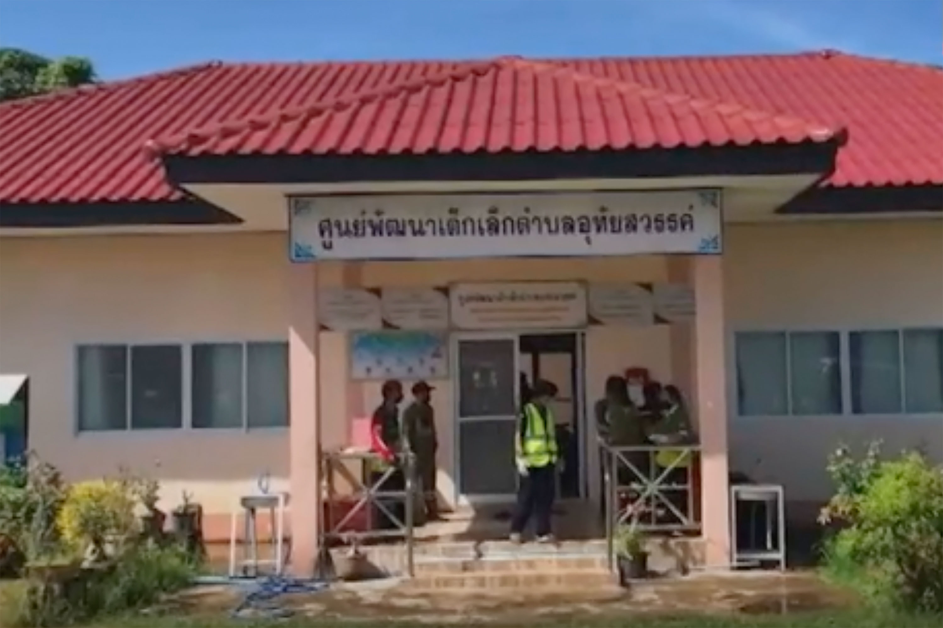 In this image taken from video, officials enter the site of the shooting in Nongbua Lamphu, Thailand, on Thursday.