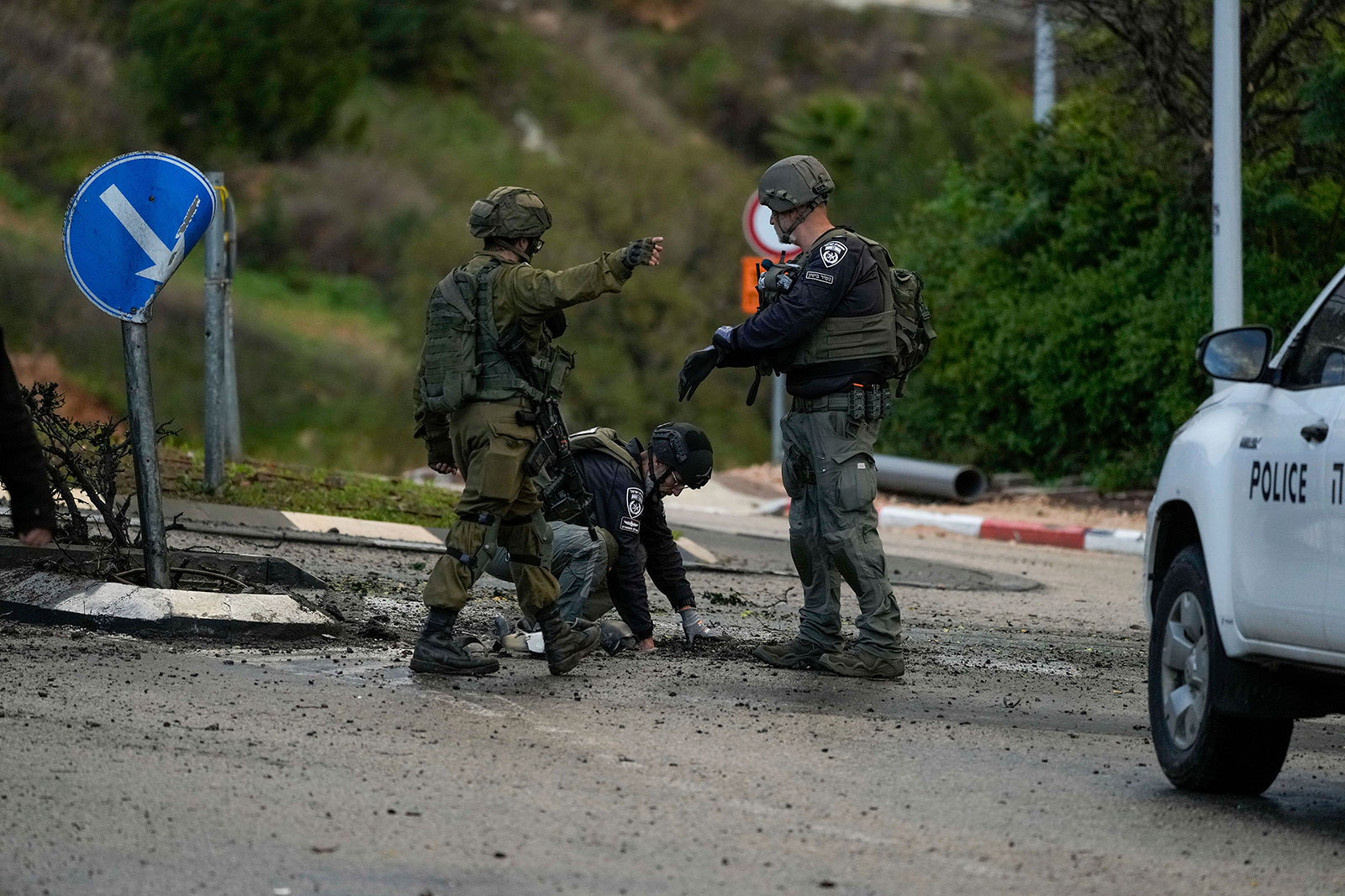 Israeli security forces examine a road hit by a rocket fired from Lebanon, in Kiryat Shmona, northern Israel, on Thursday.