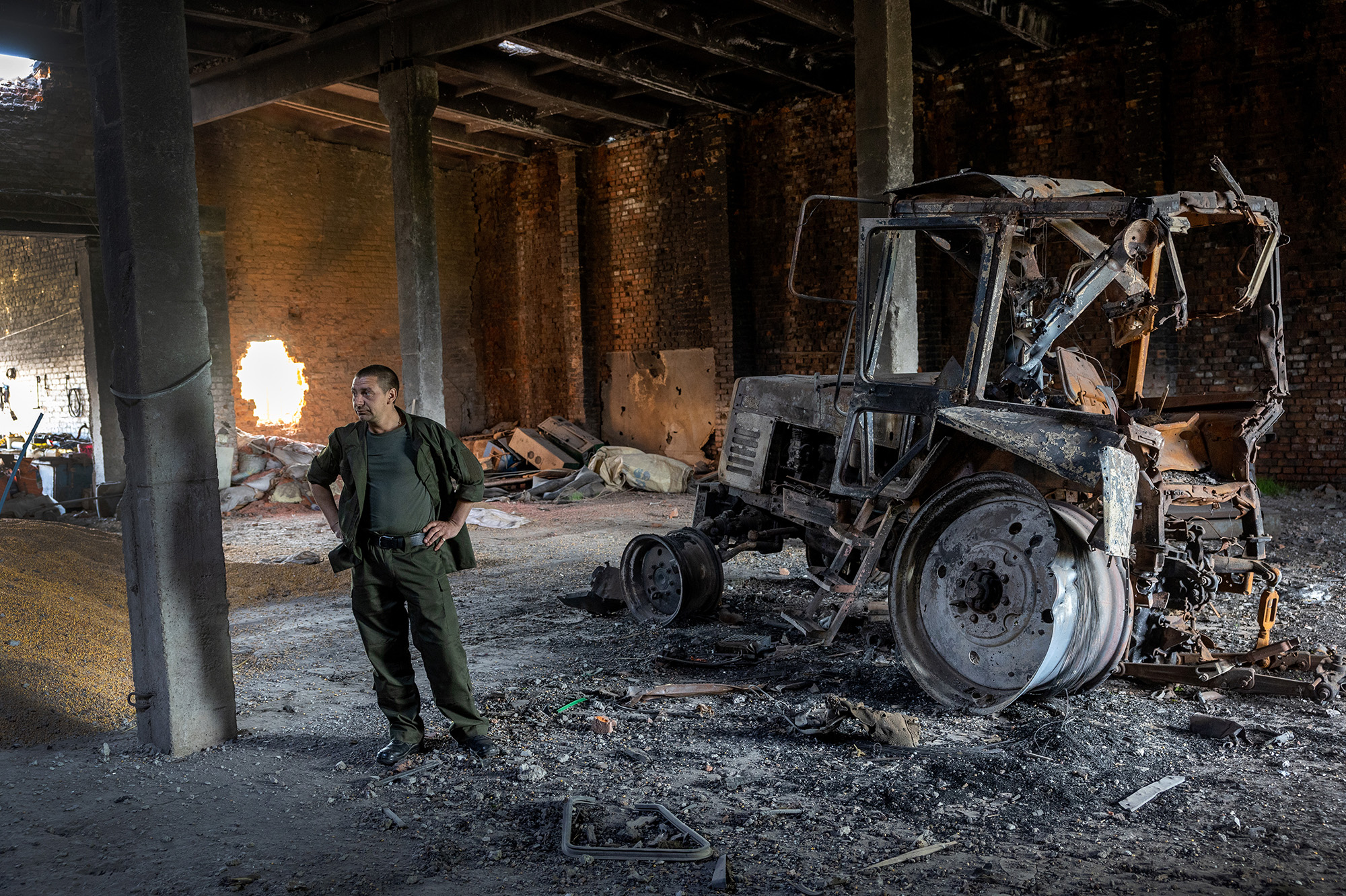 Ukrainian farm worker Misha stands near a tractor destroyed by a Russian tank shell on May 14 in Cherkska Lozova, Ukraine.  