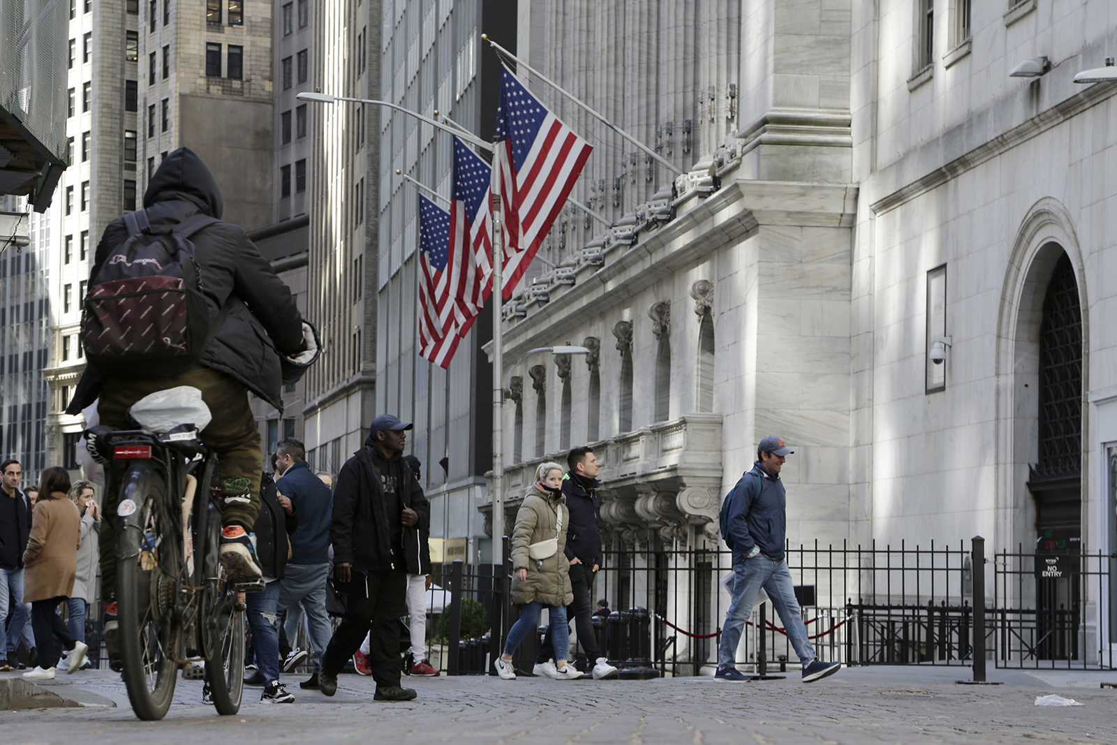 People pass the front of the New York Stock Exchange on March 21.
